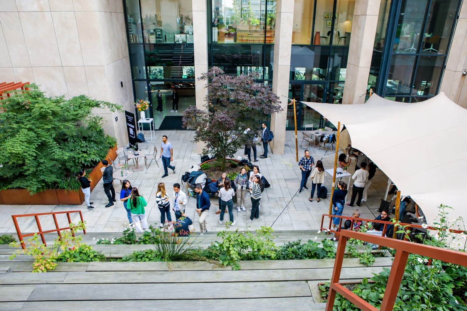 Corporate event in moderne binnentuin waar gasten samenkomen, netwerken en genieten van een ontspannen setting