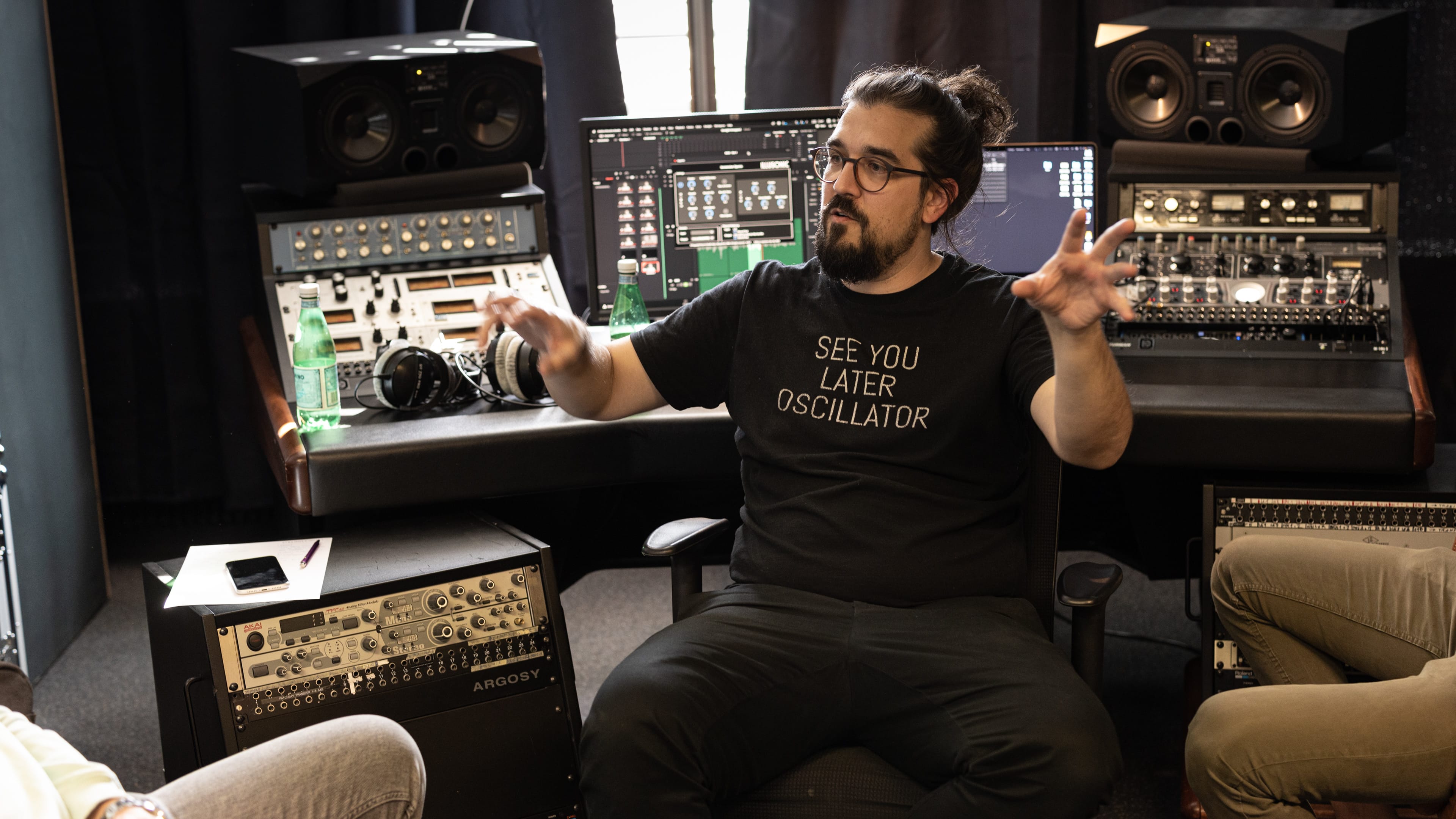 Film clapperboard in focus with glowing orange background, misty street, and silhouettes of people and lights; conveys mystery and anticipation.