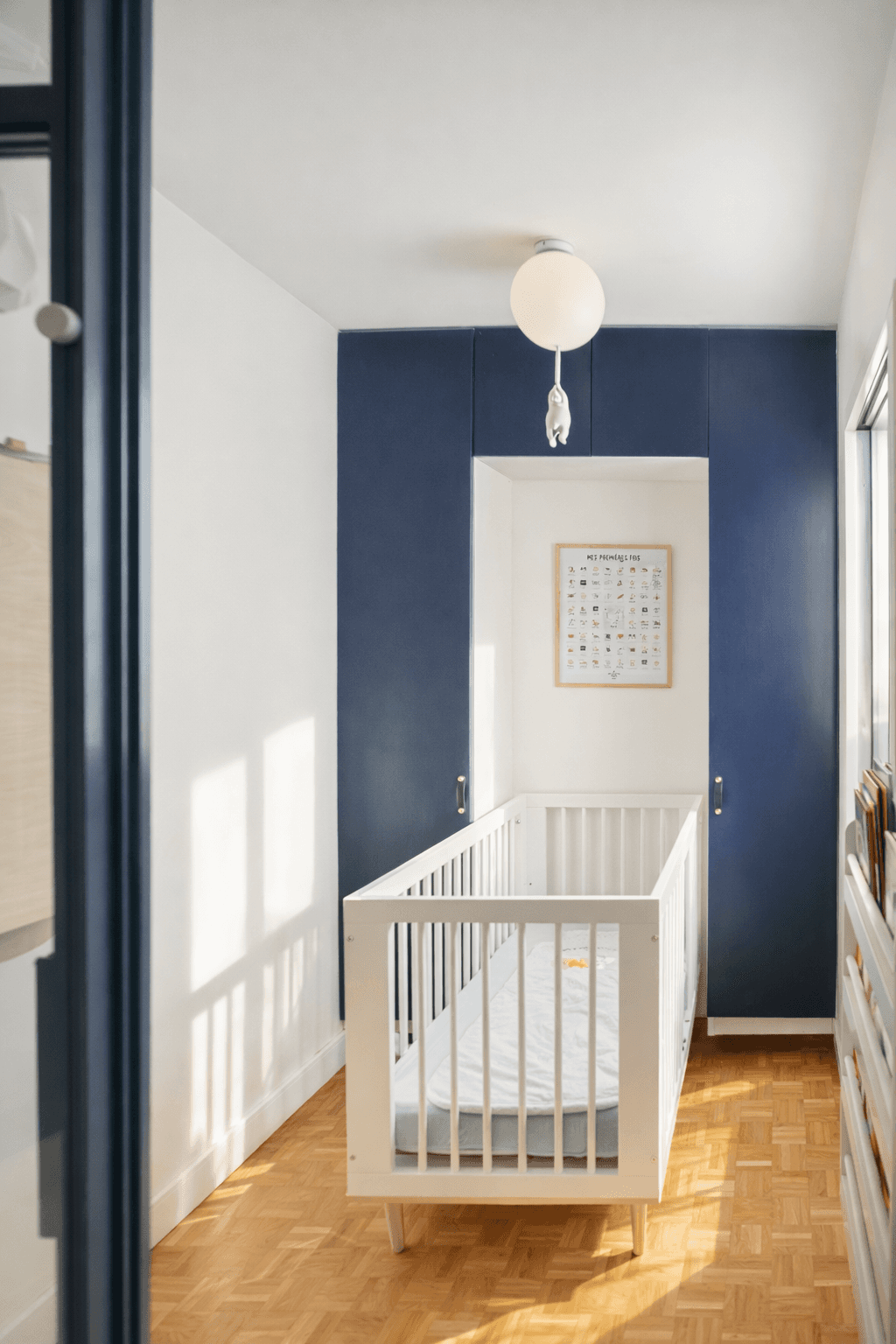 chambre bébé avec mur bleu et lit à barreaux – optimisation espace famille paris