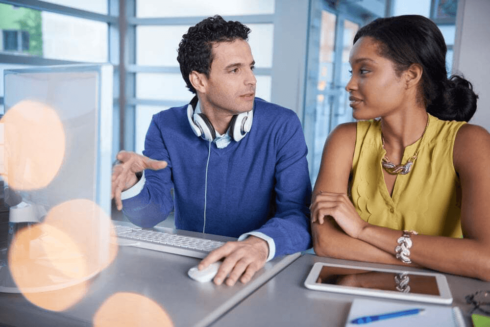 Two people looking at a laptop screen.