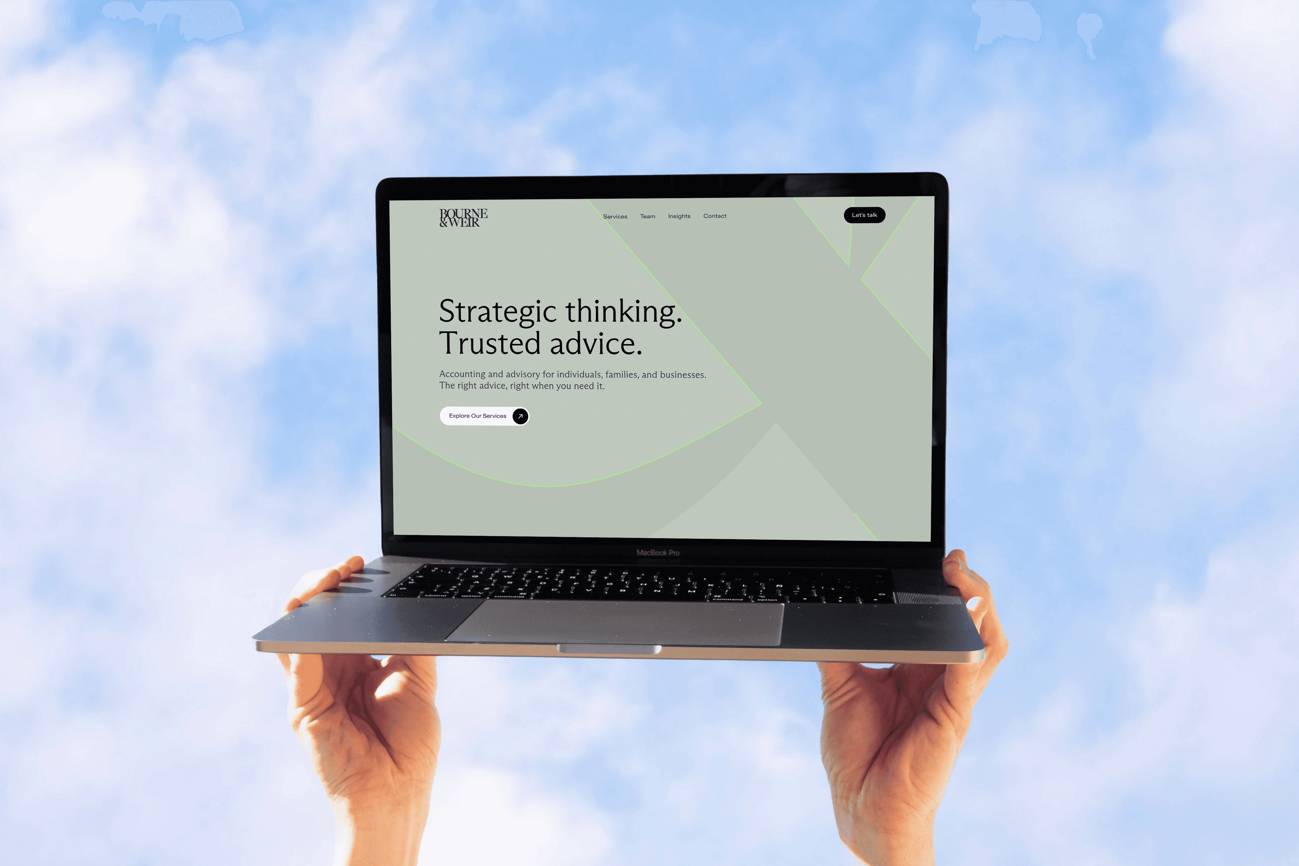 Website mockup on laptop being held by hands in the sky