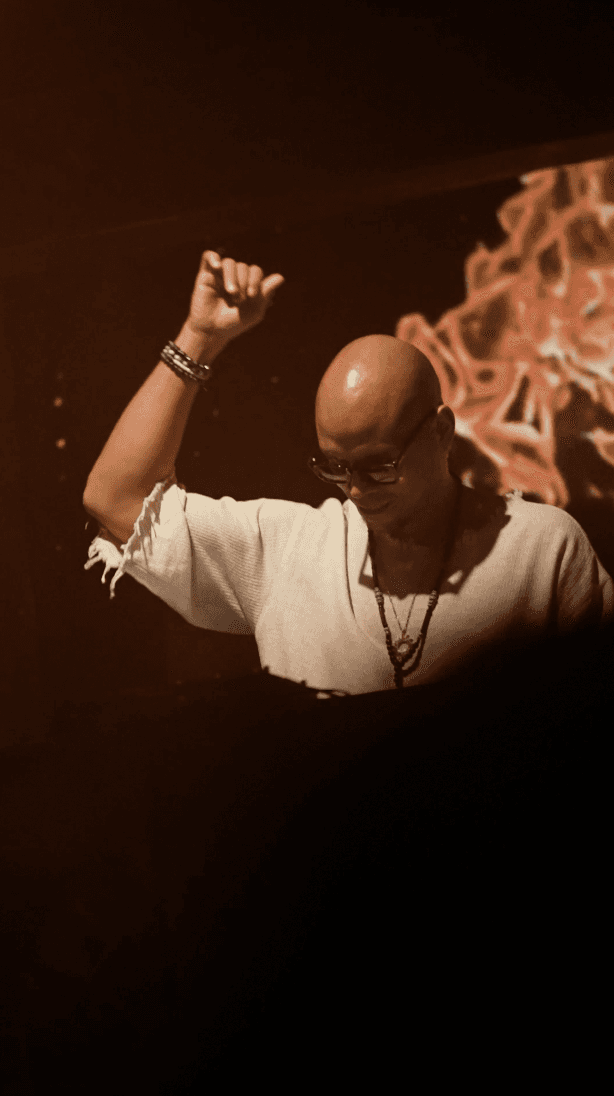 Woman in black outfit posing with arms raised