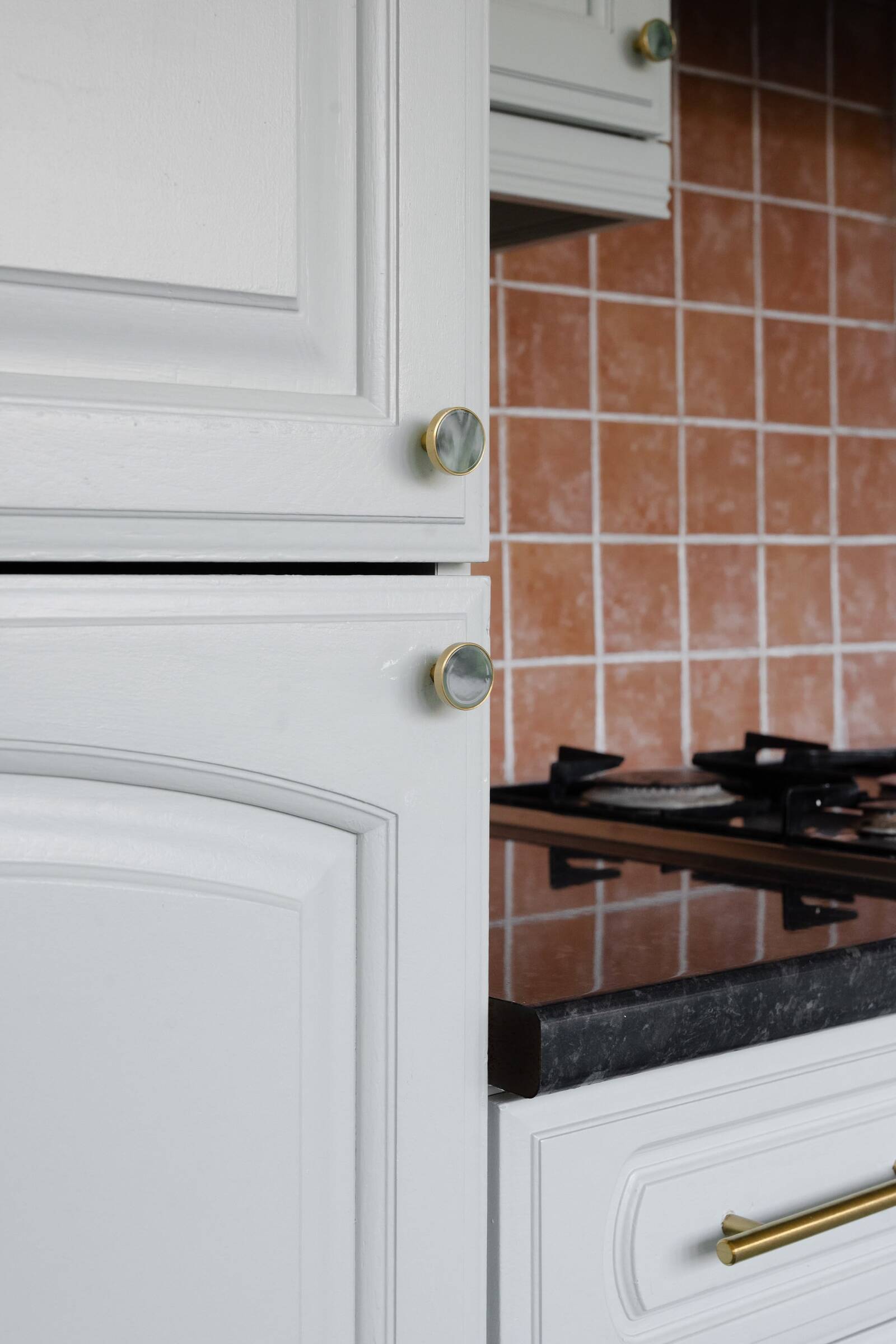 Close-up of brass kitchen doorknob in Atelier Akuko’s playful sage green kitchen, highlighting small details that elevate the space