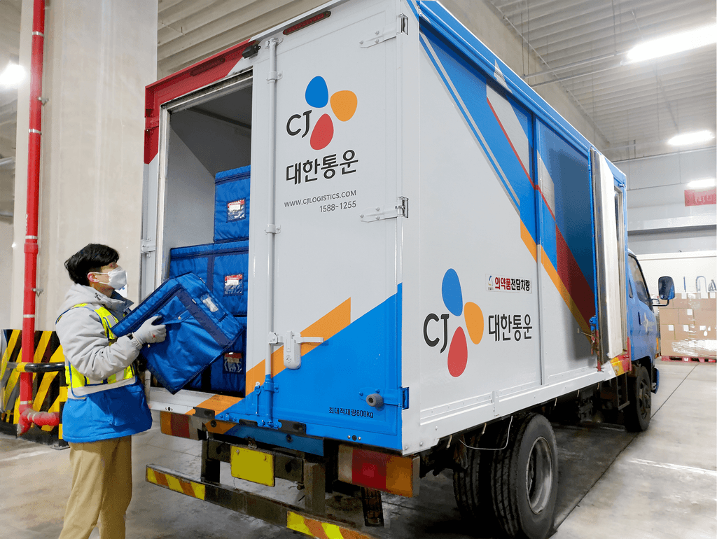 씨제이대한통운 냉동 운송 차량에서 작업자가 화물을 내리고 있습니다.