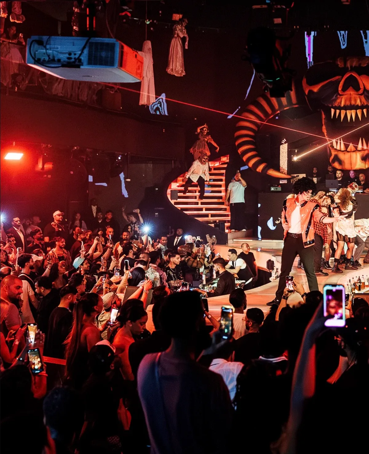 Halloween show at BLU Dubai with dancers on a spiral staircase and on stage in front of a giant skull