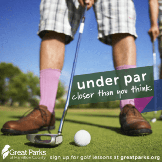A close up of the legs of a golfer, readying to put. He has colorful pink socks on.