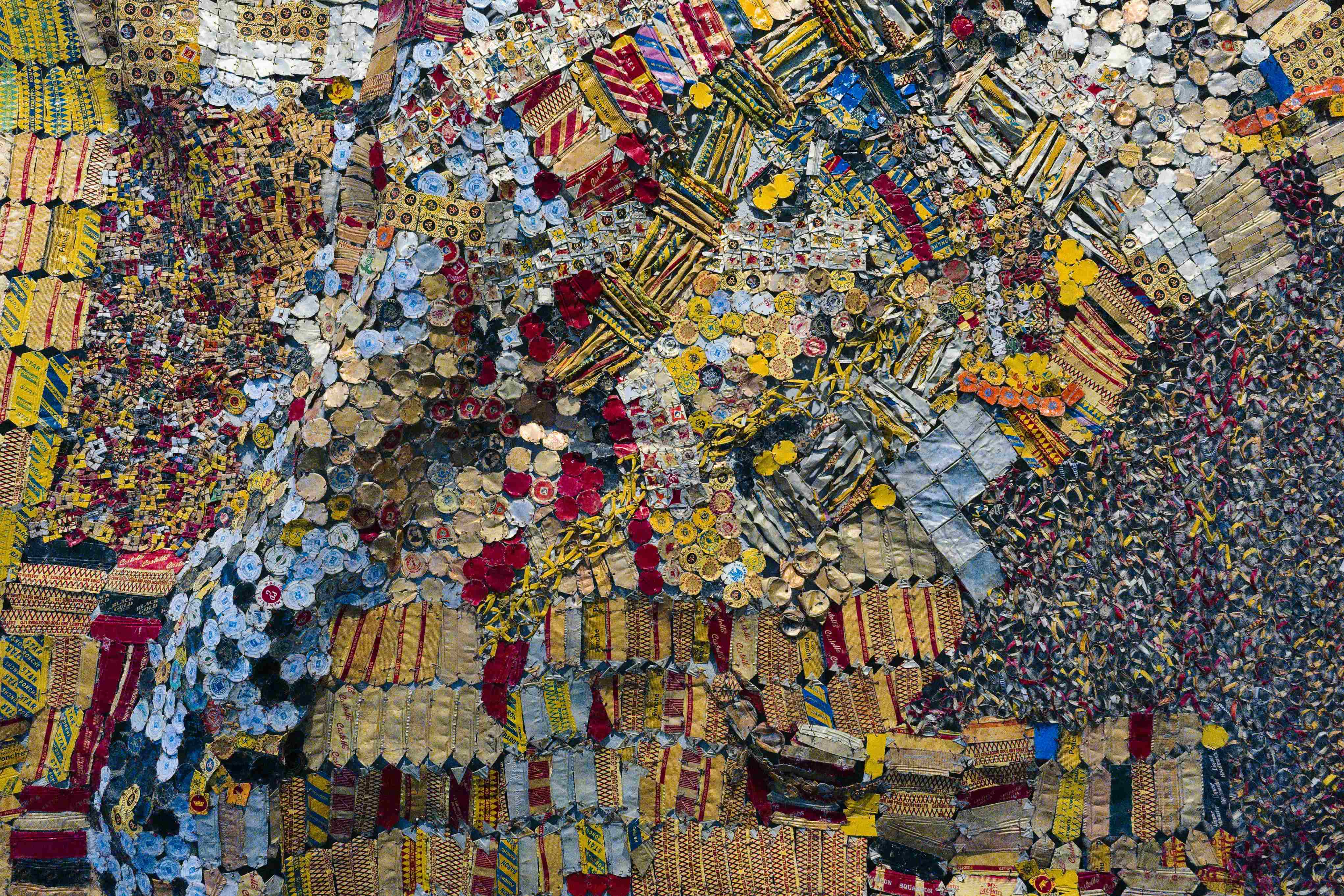 Ein lebendiges Mosaik-Kunstwerk, das aus wiederverwendeten Materialien besteht und komplizierte Muster und Texturen zeigt, die Kreativität und Nachhaltigkeit in der Kunst hervorheben.