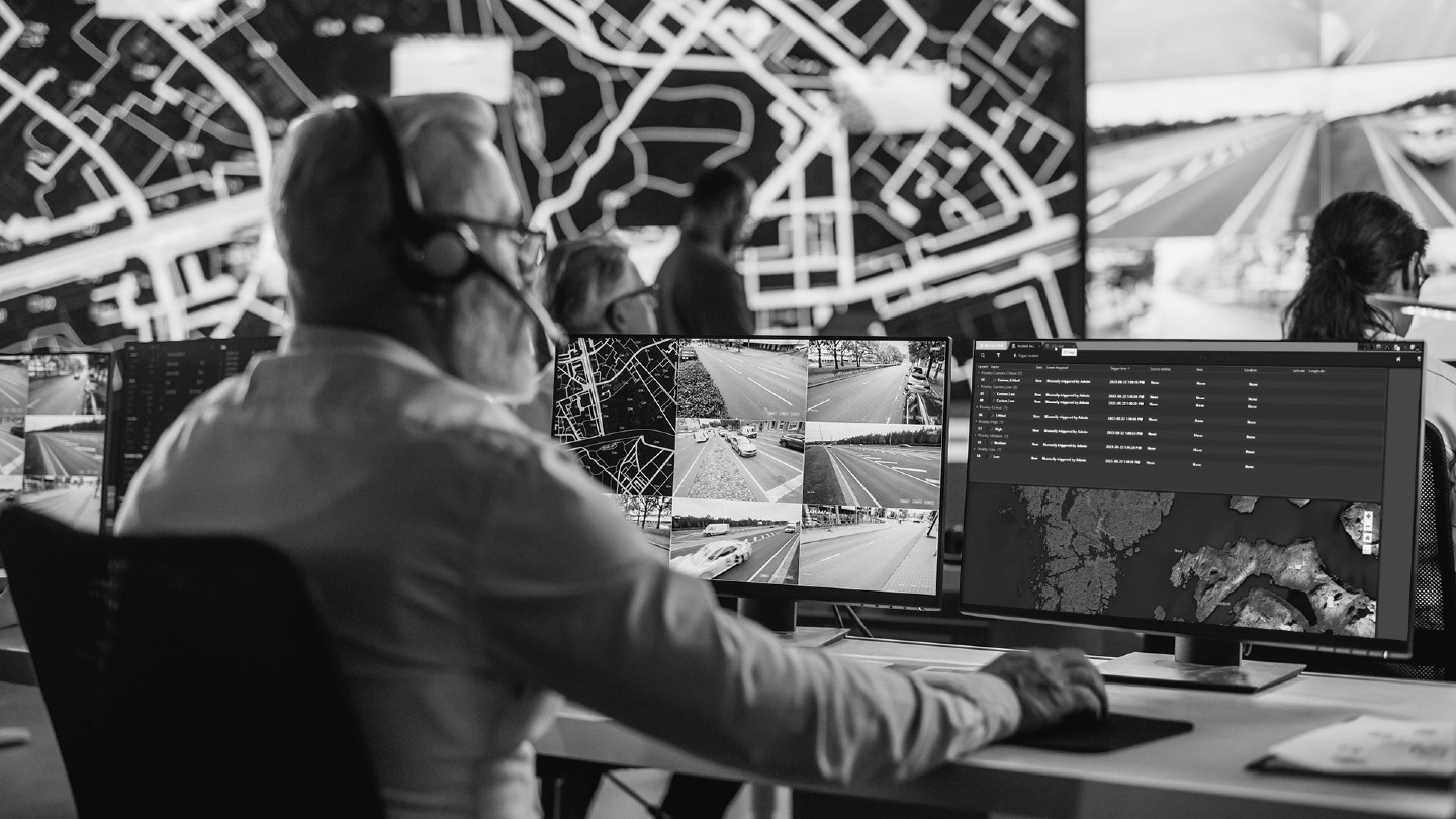 Black and white photo of an operator in a journey management control room.