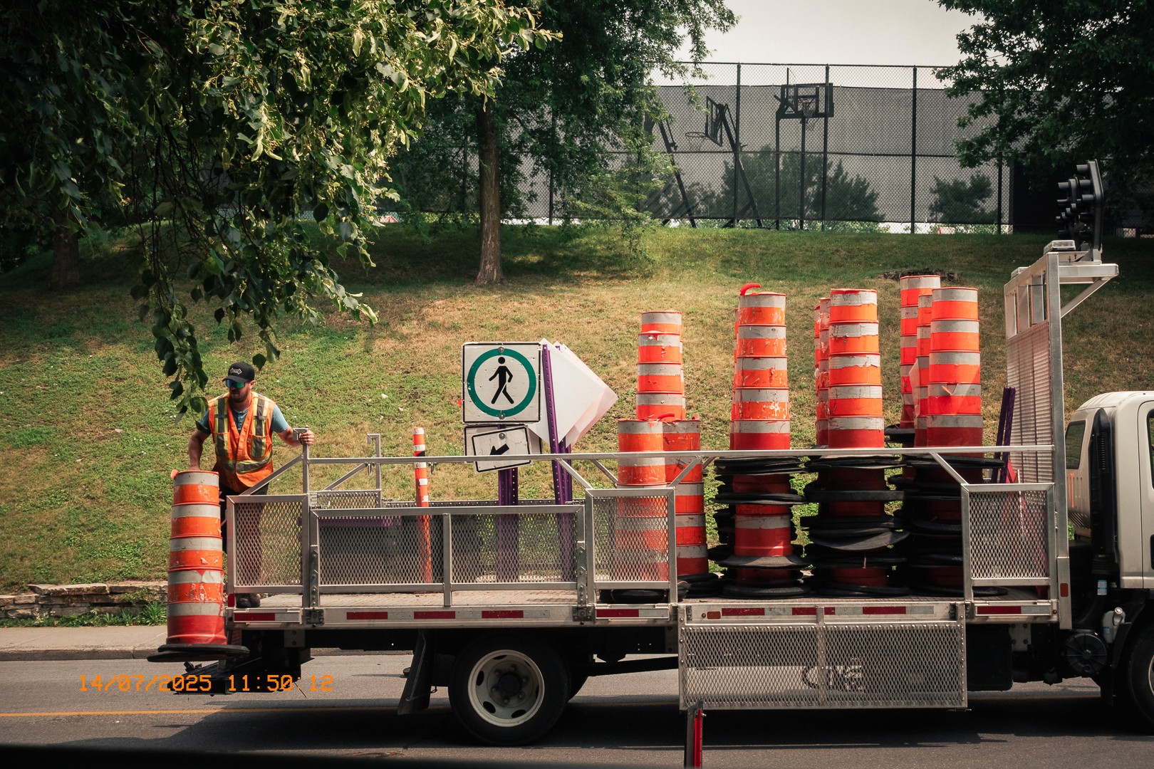 Ouvrier municipal chargeant des cônes de signalisation orange sur un camion