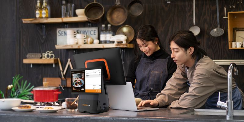 Staf di kaunter menggunakan StoreHub sistem POS.