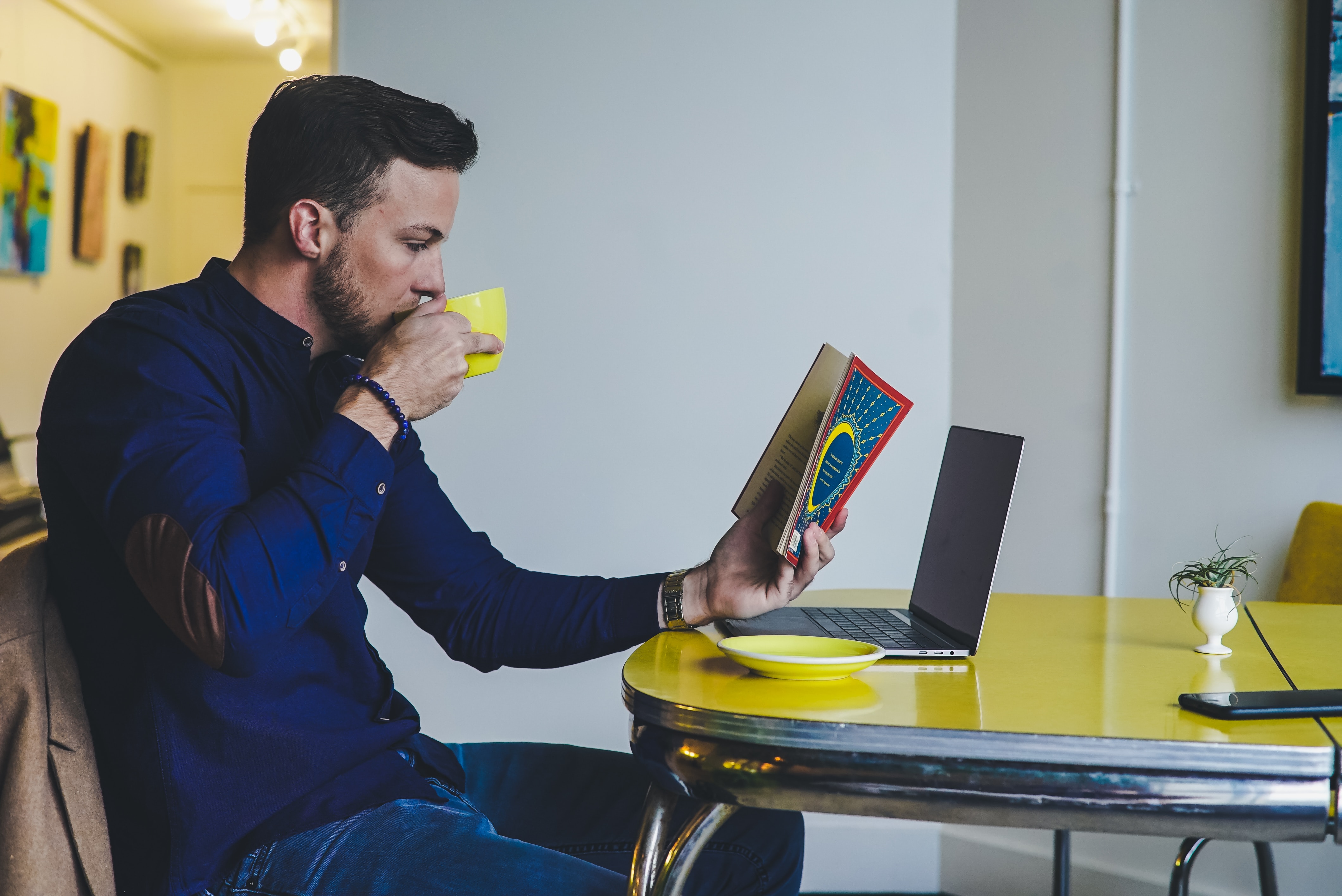 Man reading books while drinking coffee