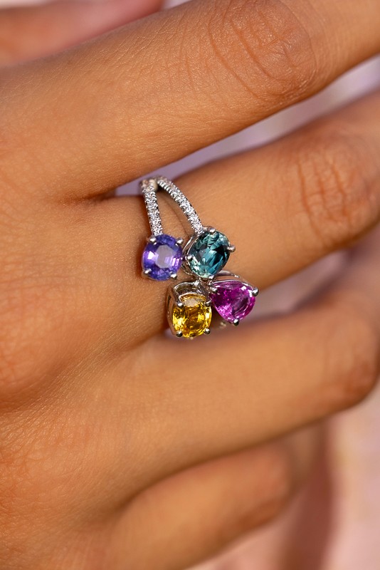 Manos de Oro Saint Barth’s artisanal ring showcasing four vibrant gemstones—pink, yellow, teal, and violet—set in a sparkling embrace of handcrafted silver luxury.