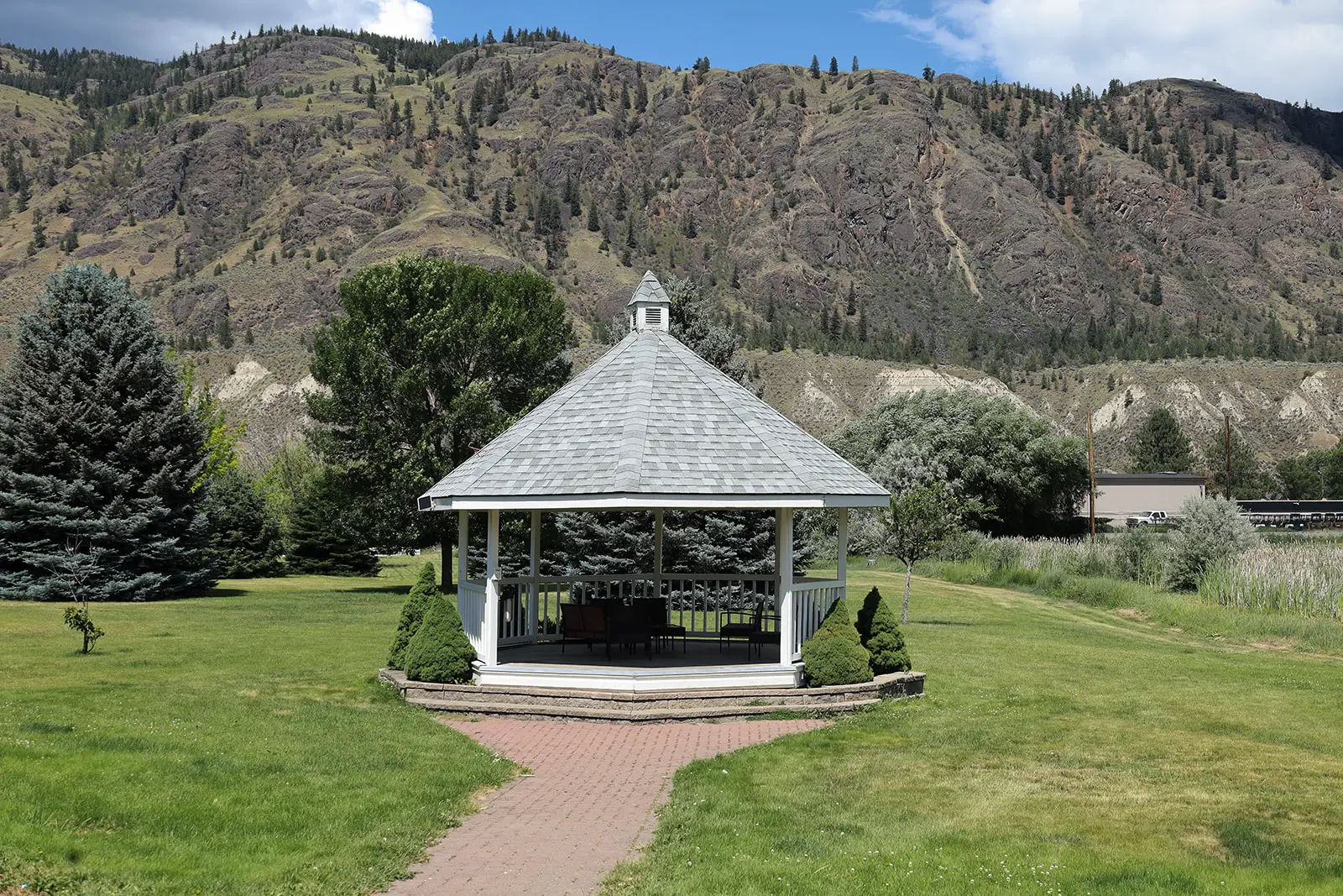 Gazebo in a park with a mountain range in the background.