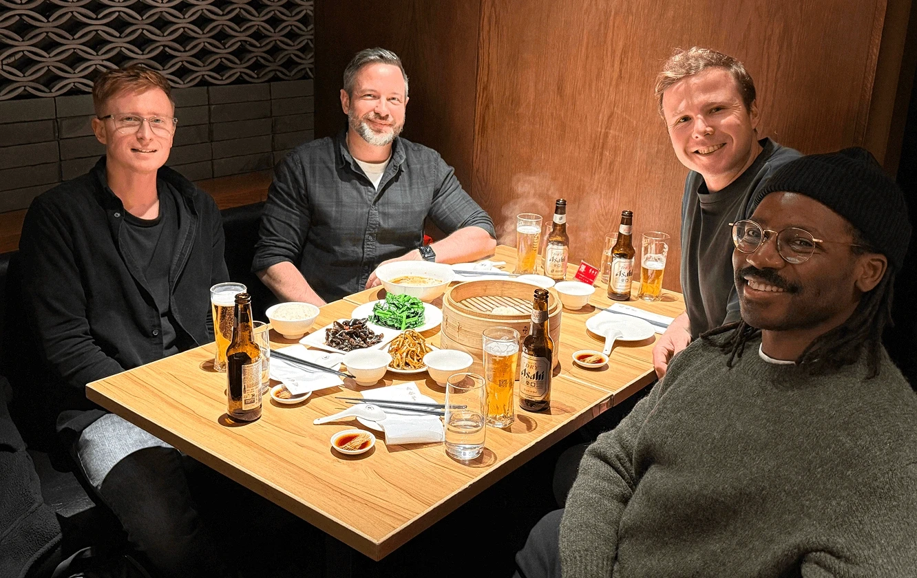 Team dinner with shared dishes and drinks around a restaurant table.