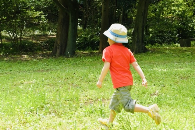 木に囲まれて走る子供