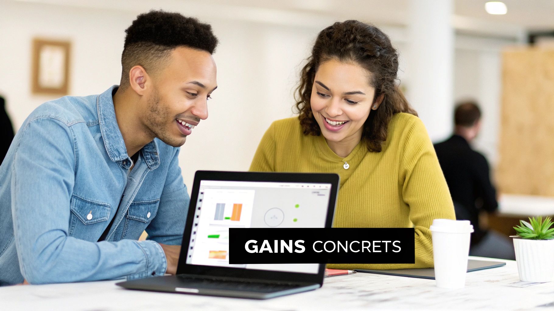 Deux personnes souriantes, un homme et une femme, examinent des graphiques sur un ordinateur portable, travaillant ensemble.