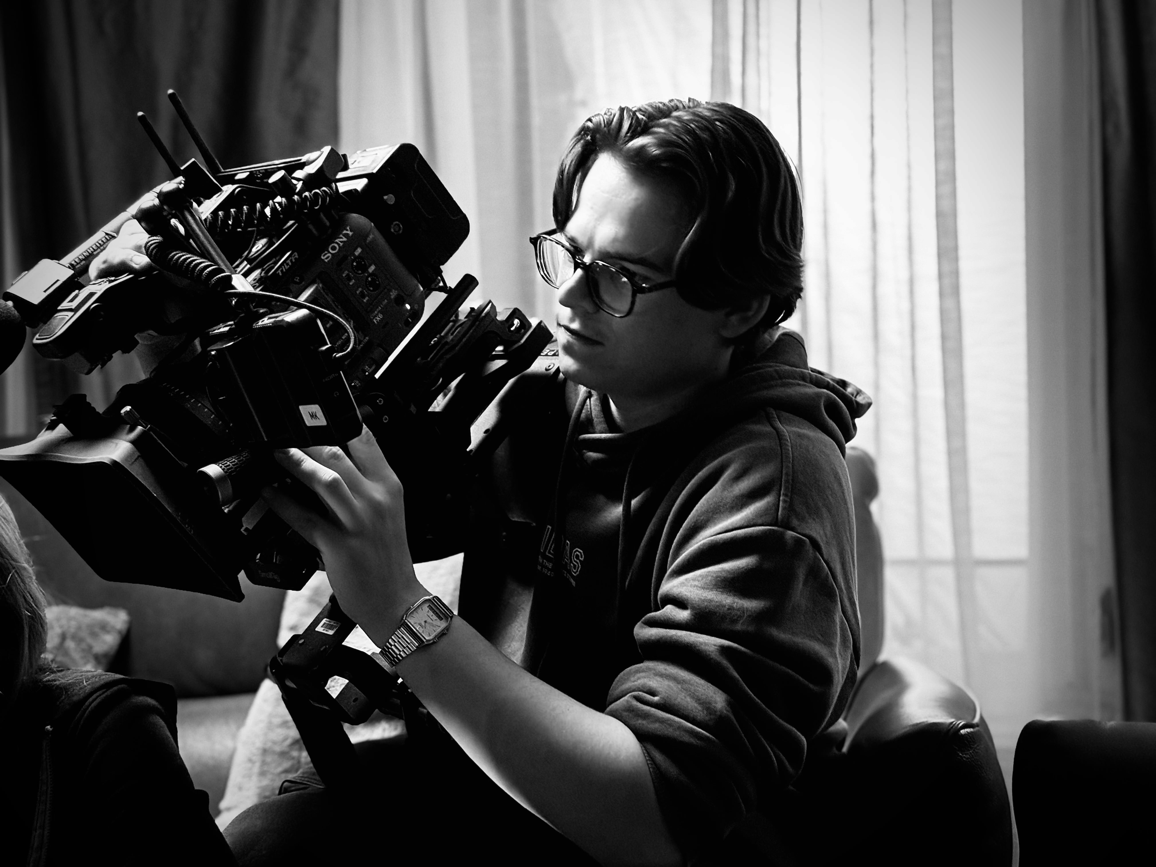 Person, holding a white rose behind his back with one arm on a light blue background