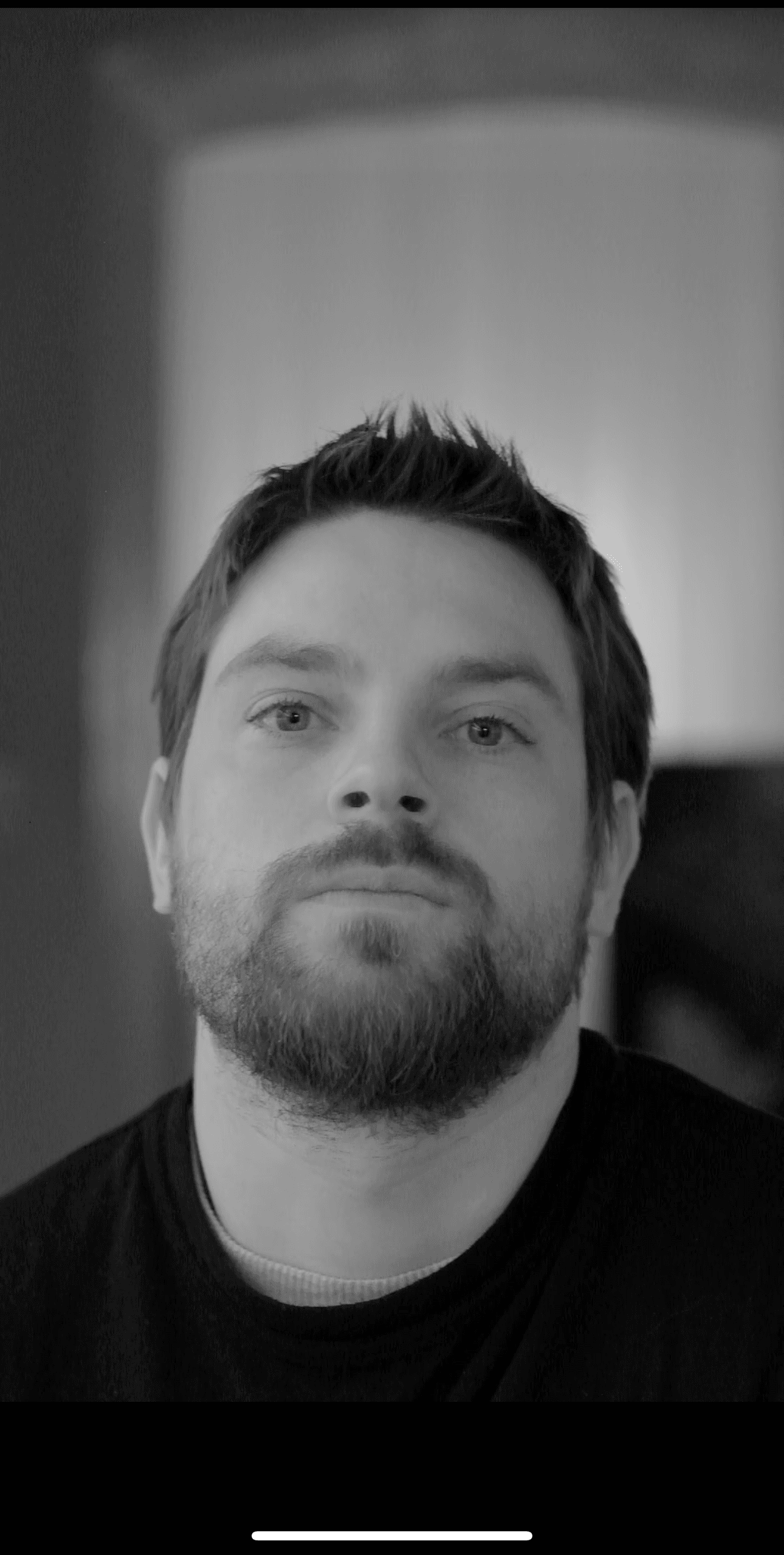 A woman observes framed black-and-white photographs in warm golden light