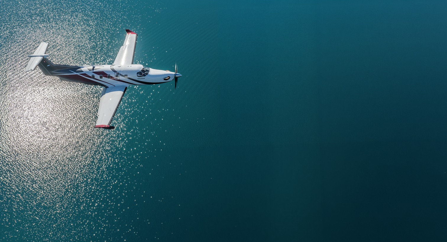 Pilatus PC-12 flying over lake