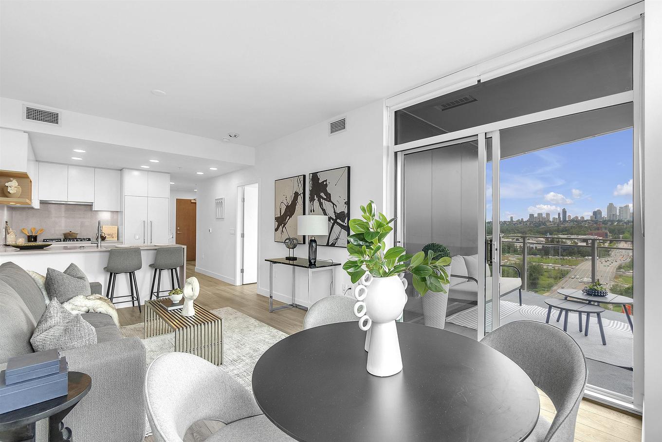 A modern, bright living room and dining area with circular table, plush chairs, and large windows showcasing a view.