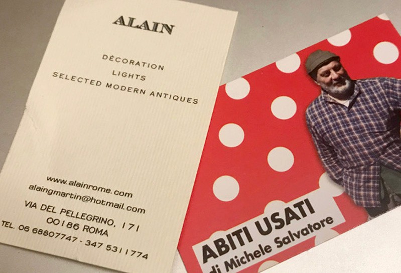 A white and a red paper flier with a man in a checkered shirt. The title on the fliers: Abiti Usati di Michele Salvatore. Alain Decoration Lights Selected Modern Antiques.