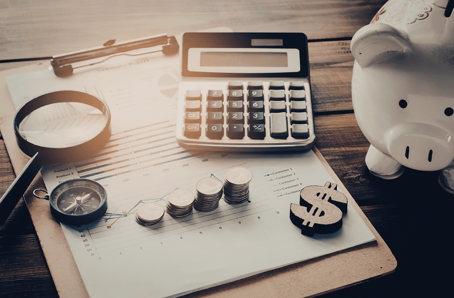 Financial analysis setup with calculator, coins, and piggy bank illustrating tracking ad spend and identifying wasted Amazon PPC budget.