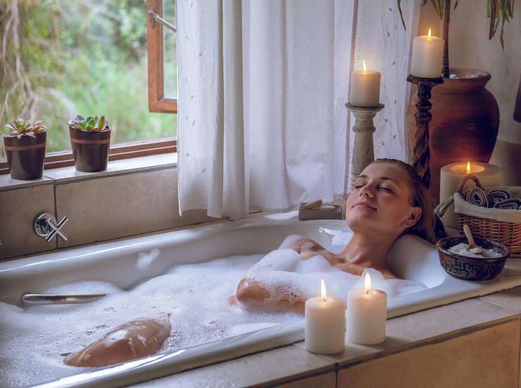 woman taking a relaxing hot Epsom salt weight loss bath with candles for ambiance