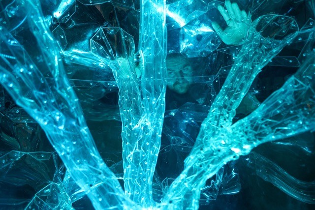 Woman wears a blue coat in a blue environment.