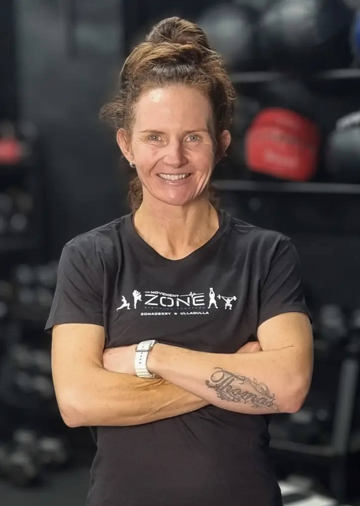 Coach Anto Newton posing in The Movement Zone shirt inside the training facility.