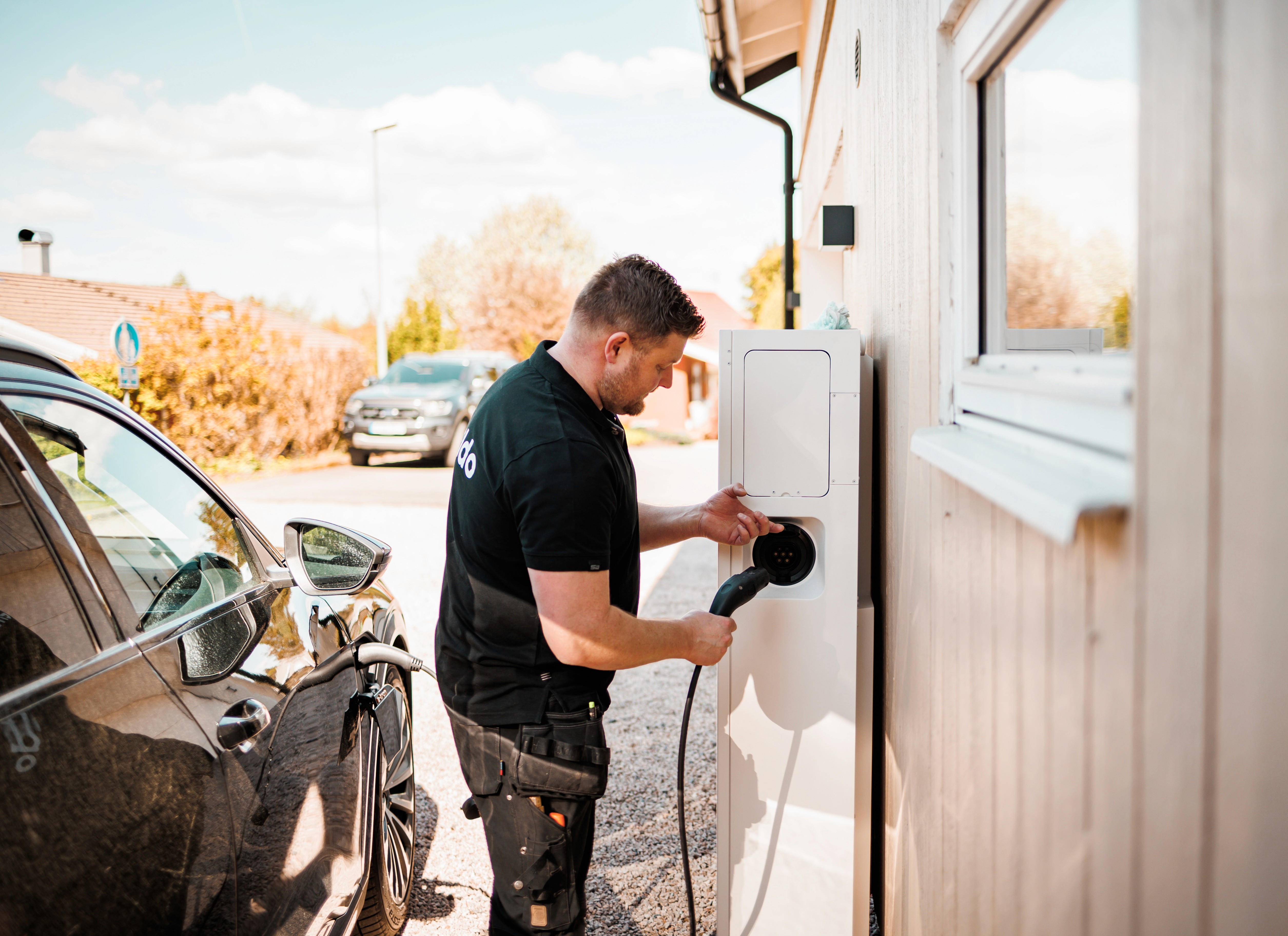 A winding road cuts through rocky terrain, surrounded by patches of green grass and illuminated by sunlight.
