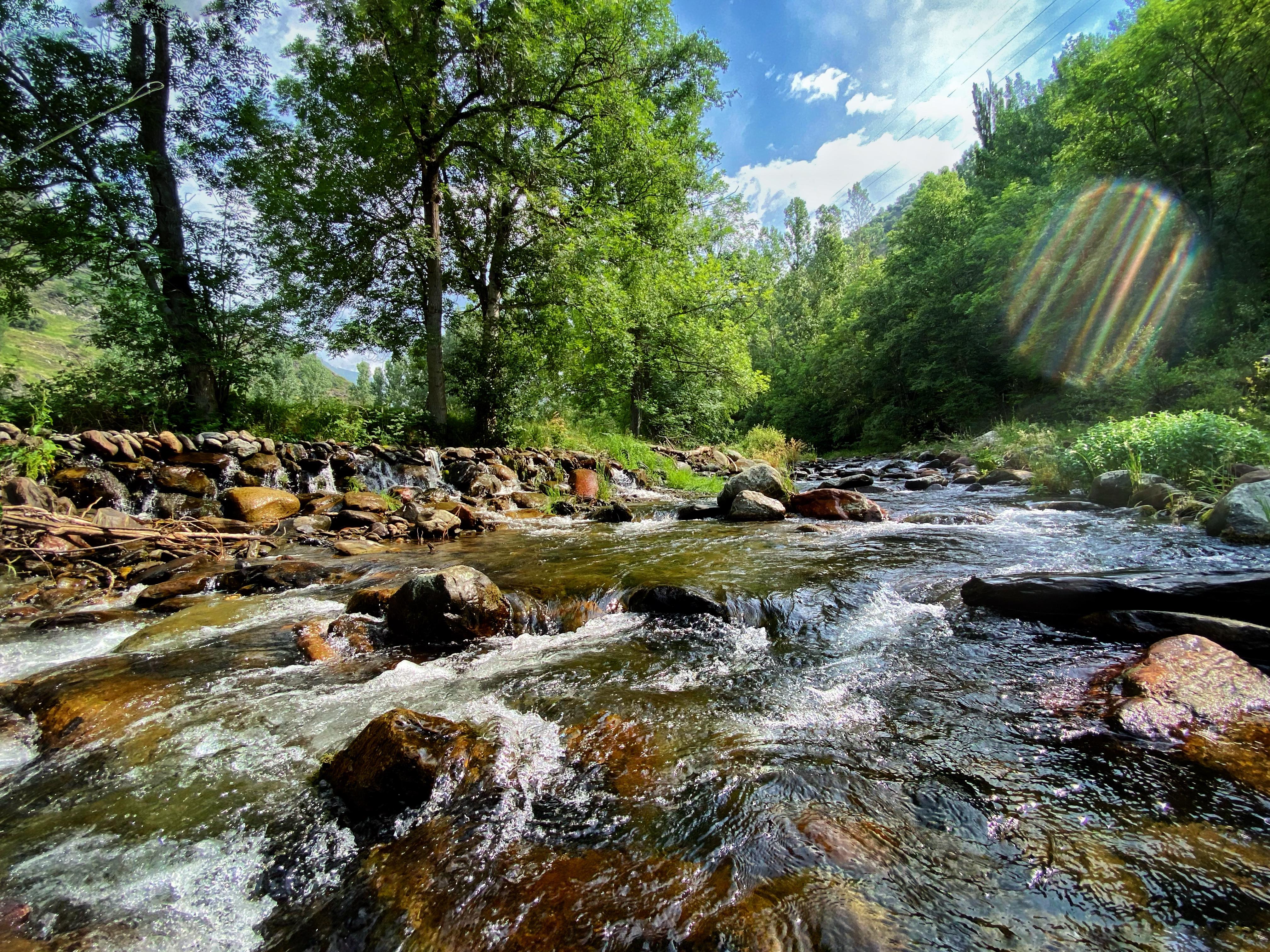 Panoramic view of the Pyrenees with an angler fly fishing in the morning light near Barcelona, Spain.