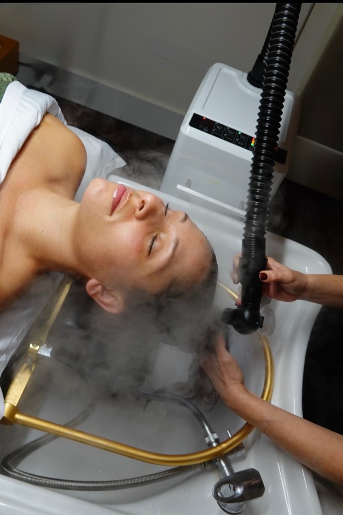 Woman in a spa getting steam applied to her scalp