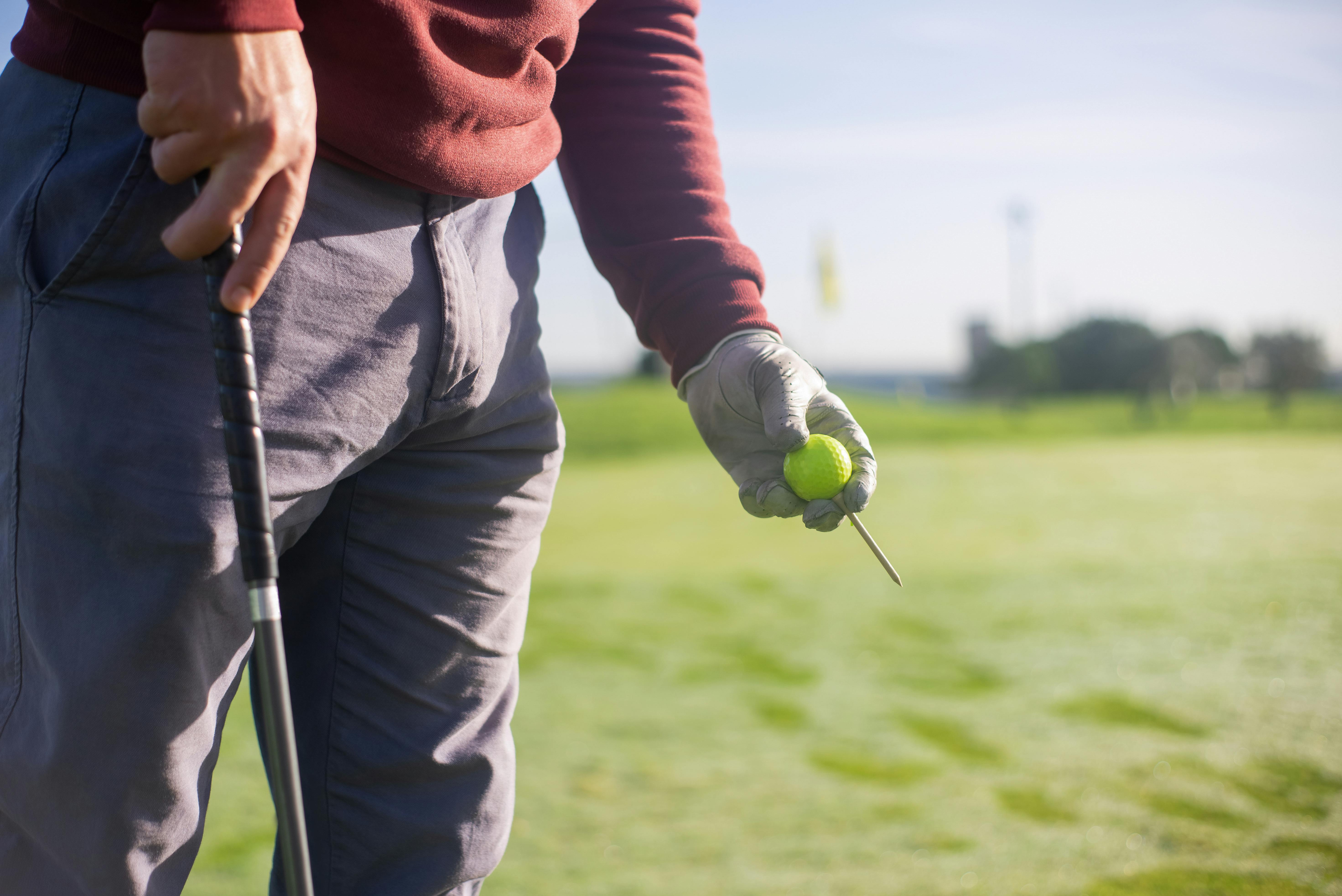 photo of man swinging golf driver