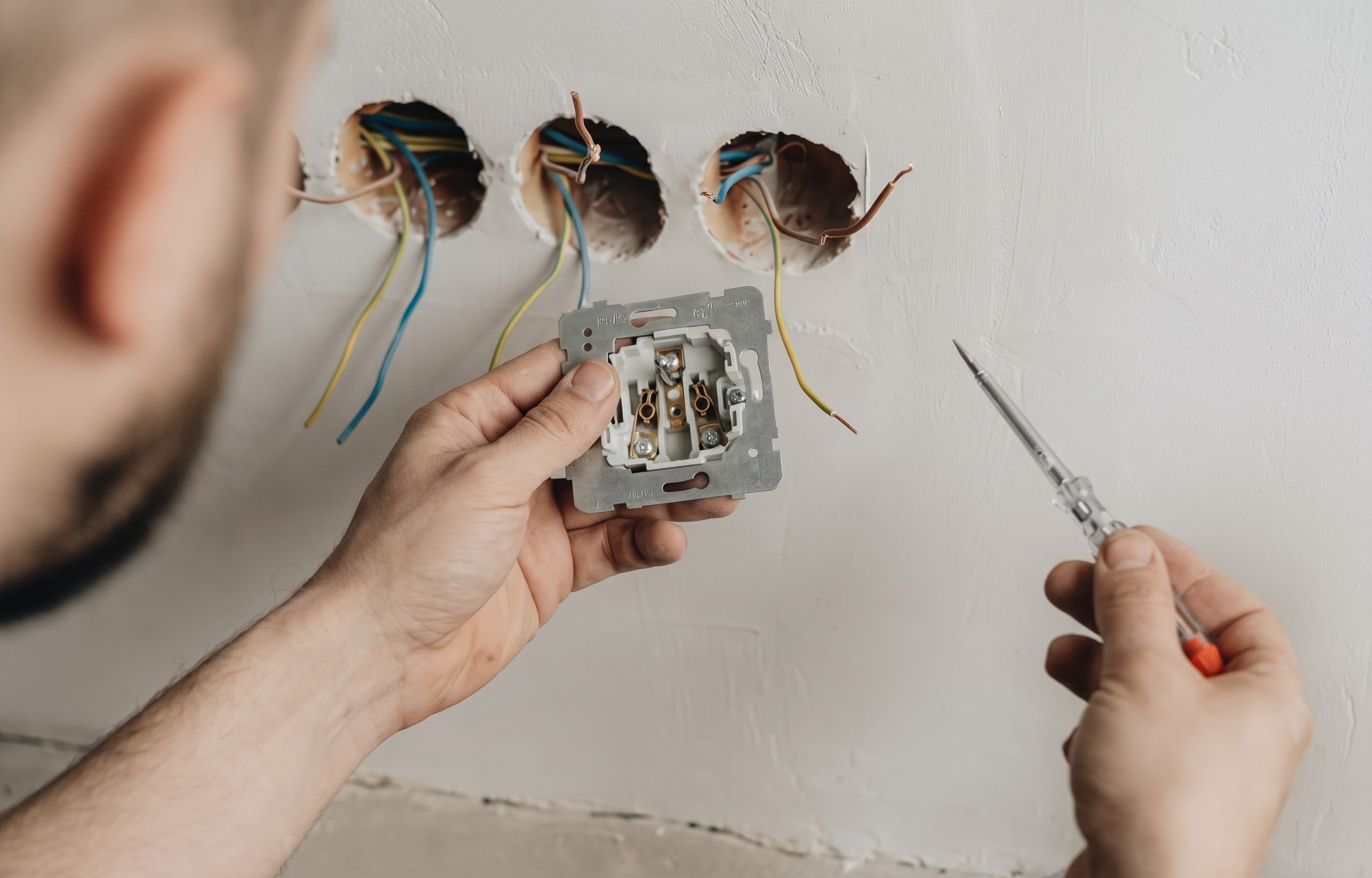 Électricien vérifiant un tableau électrique lors d'une mise aux normes