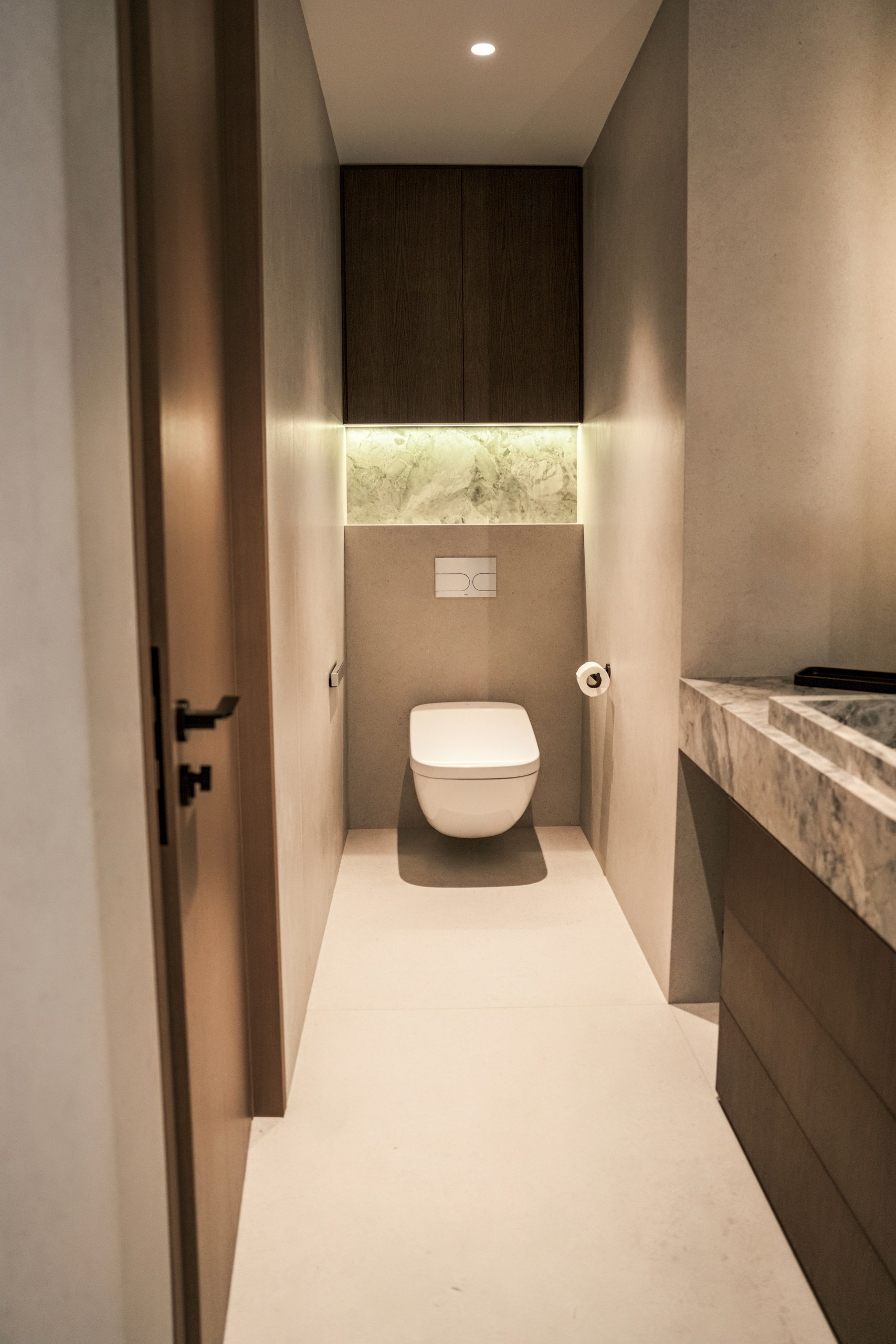 WC with wall-hung toilet and backlit stone niche in the Vida Marina penthouse renovation