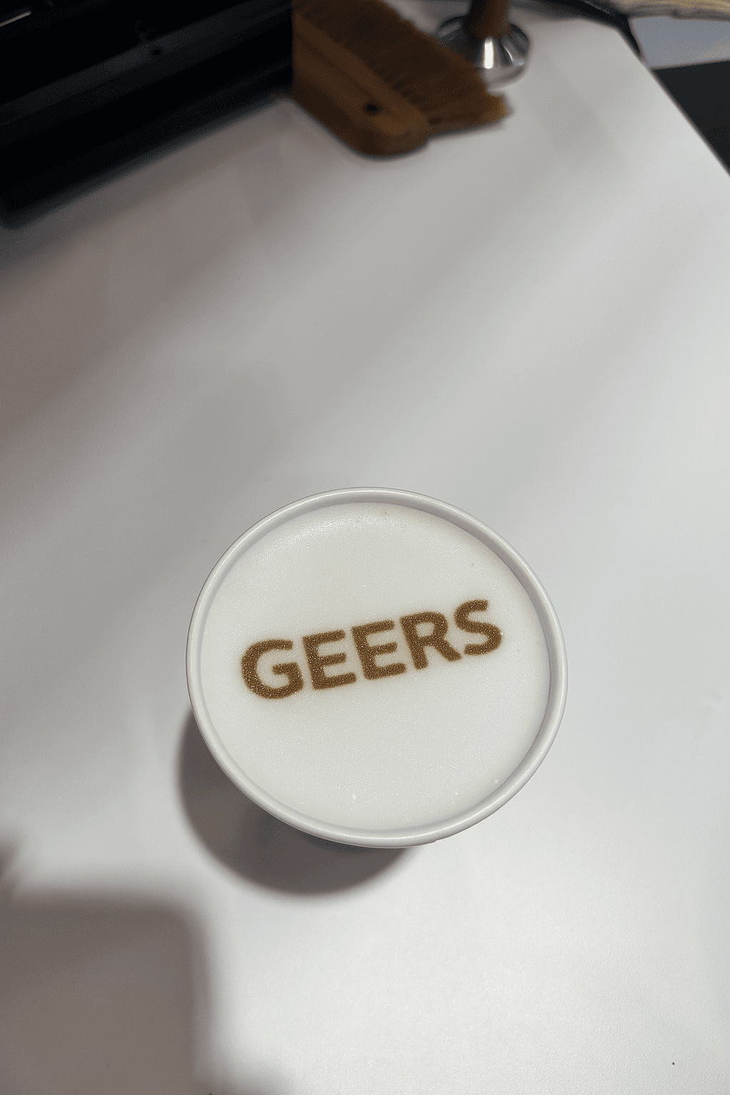 Kaffeebohnen neben einer weißen Tasse Espresso