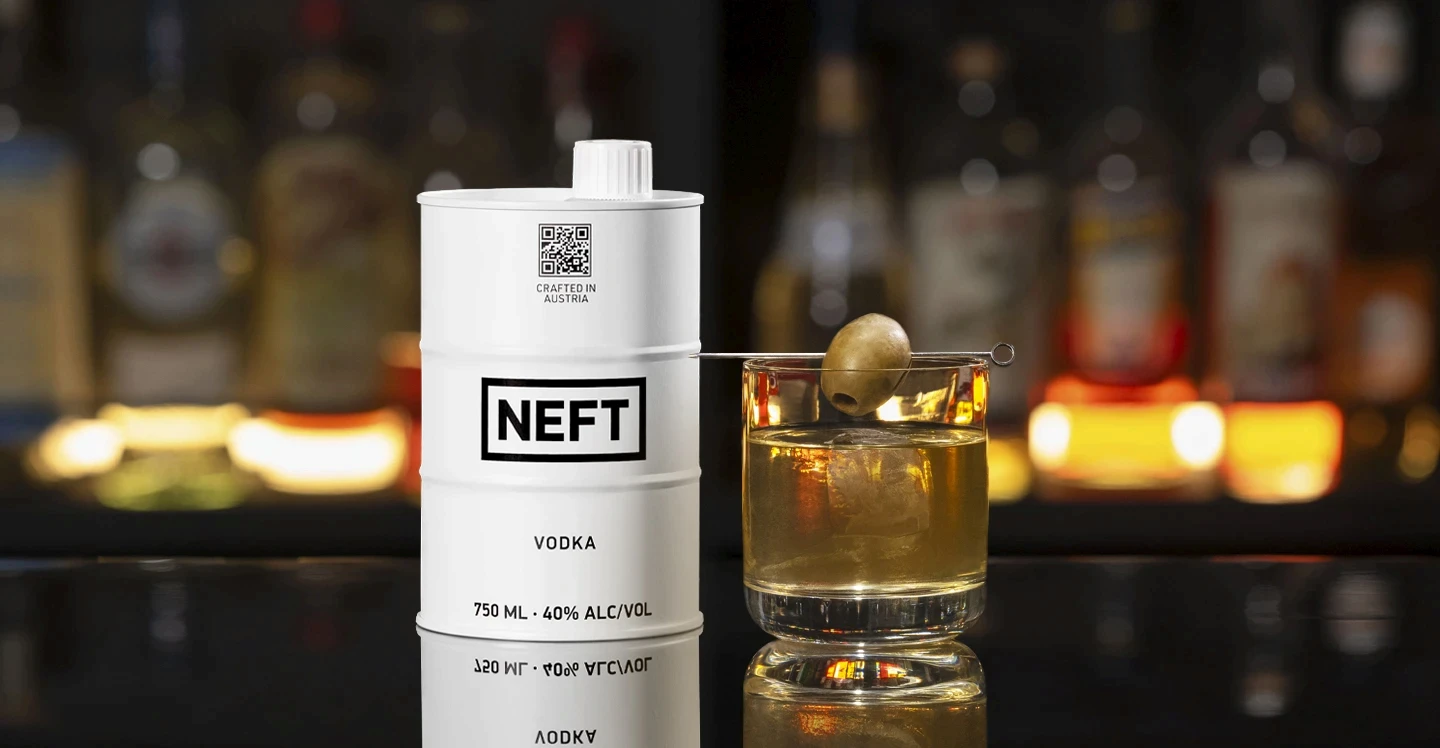 A NEFT Vodka Barrel and a glass of Dirty Double on a bar counter.