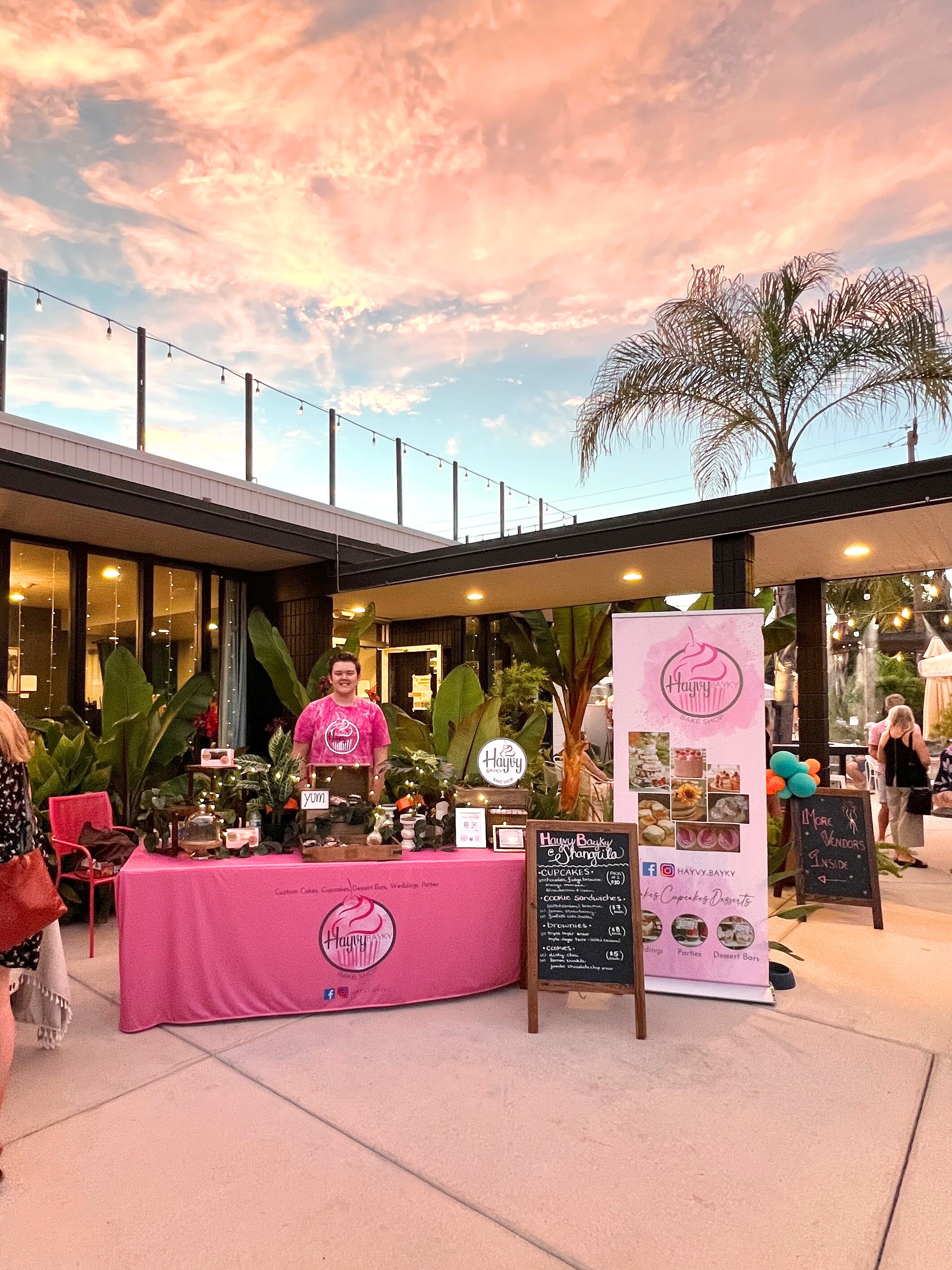 Two people talking at table in plant-filled café