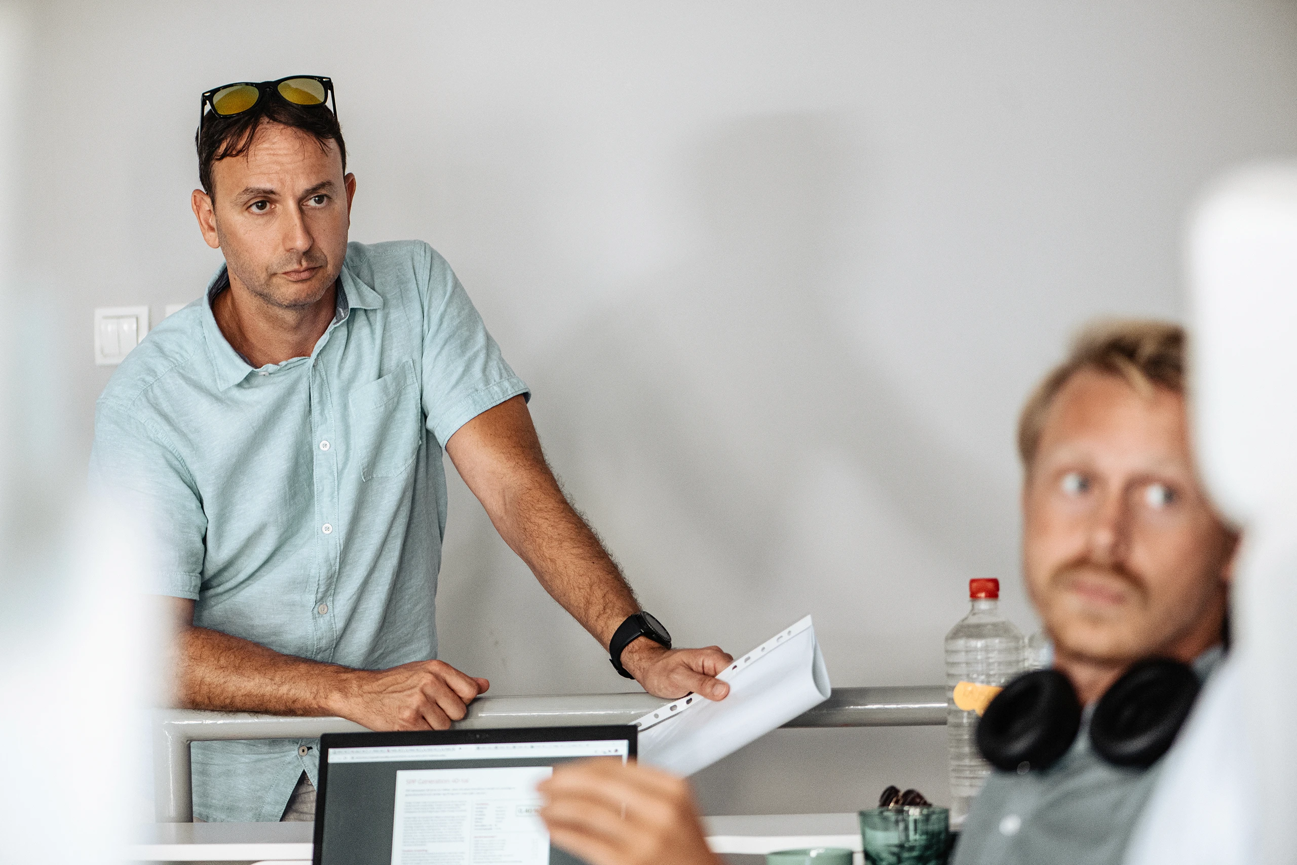 Team discussion during a workday, reviewing documents in a collaborative office environment.