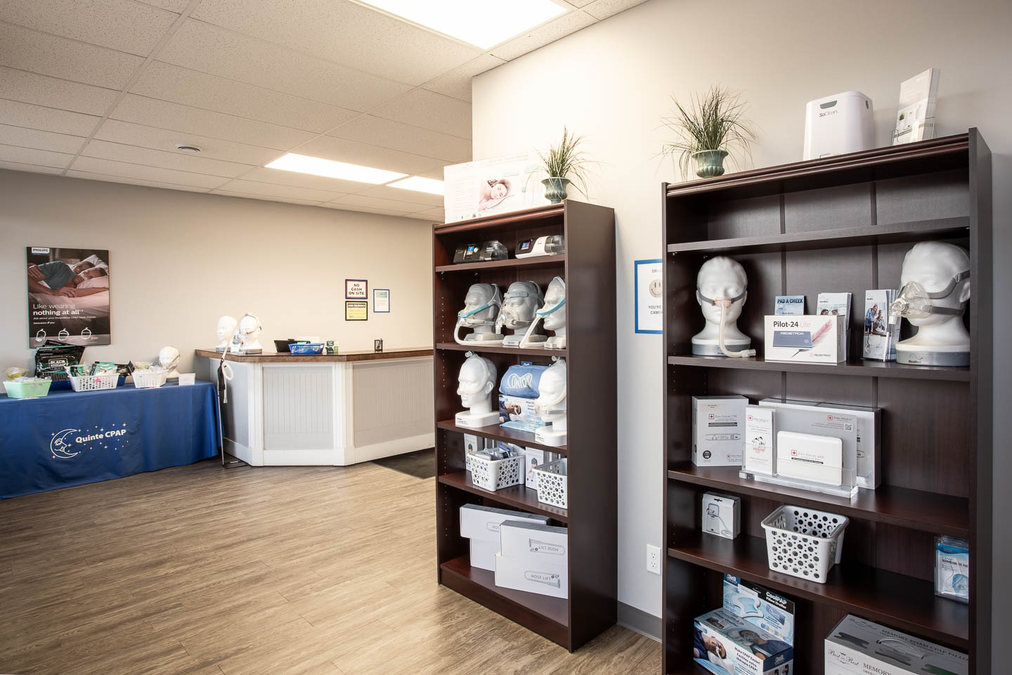 Two shelving units with CPAP machines on busts at the beginning of a clinic reception area.