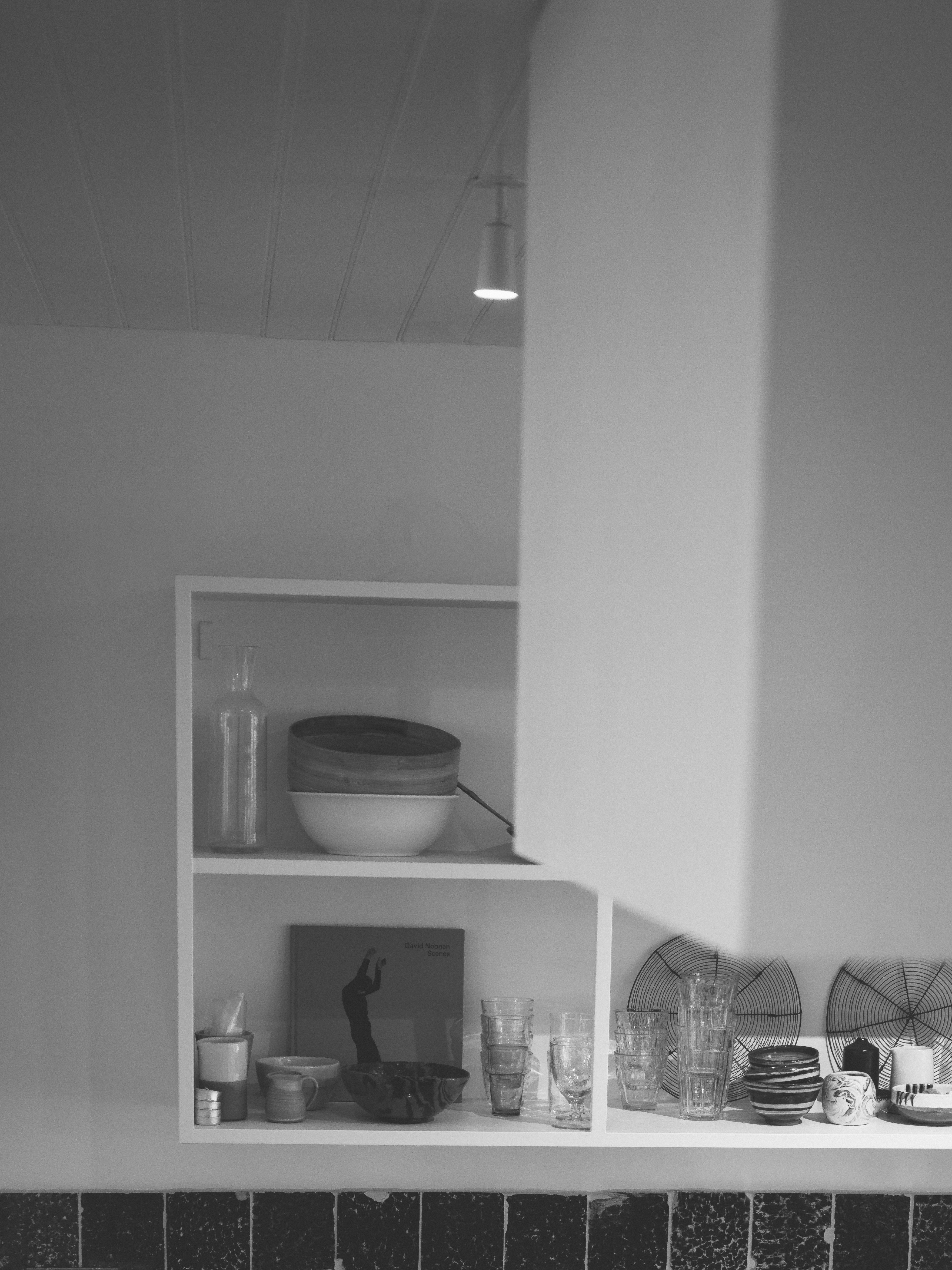 Black and white fireplace detail with minimal decorative shelving
