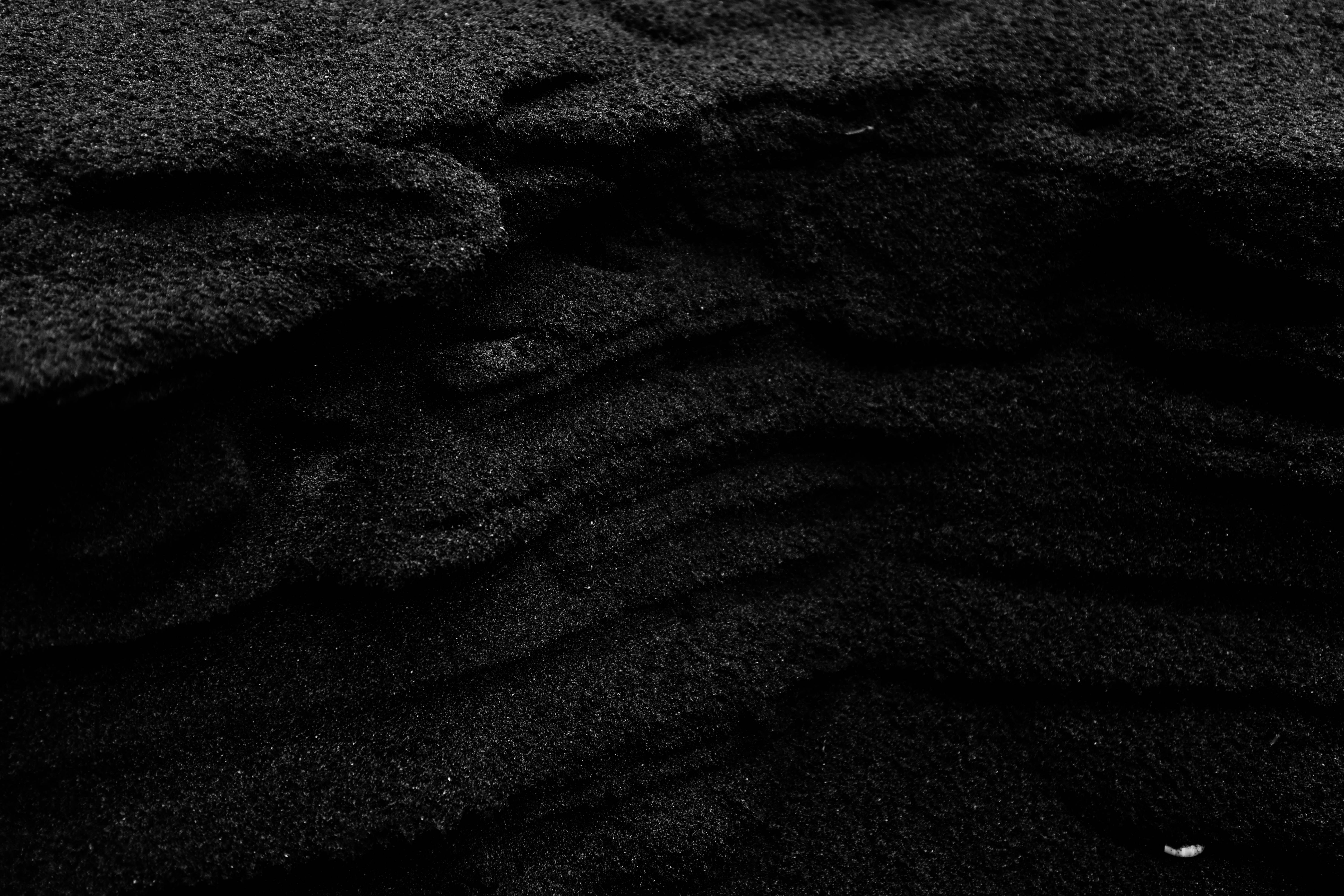 a black and white photo of sand and water