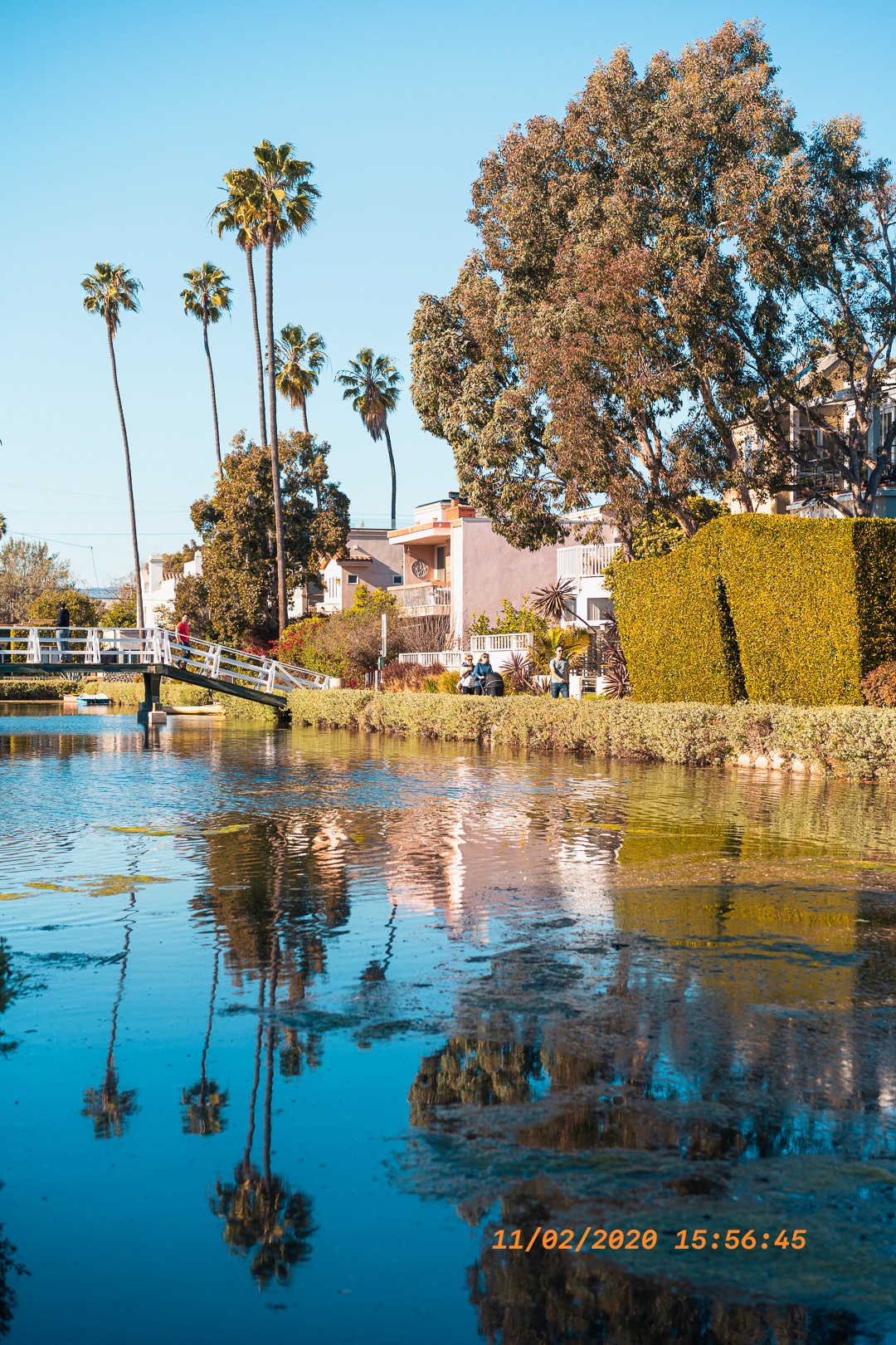 Scène paisible des Venice Canals, avec des maisons et un pont au bord de l'eau.