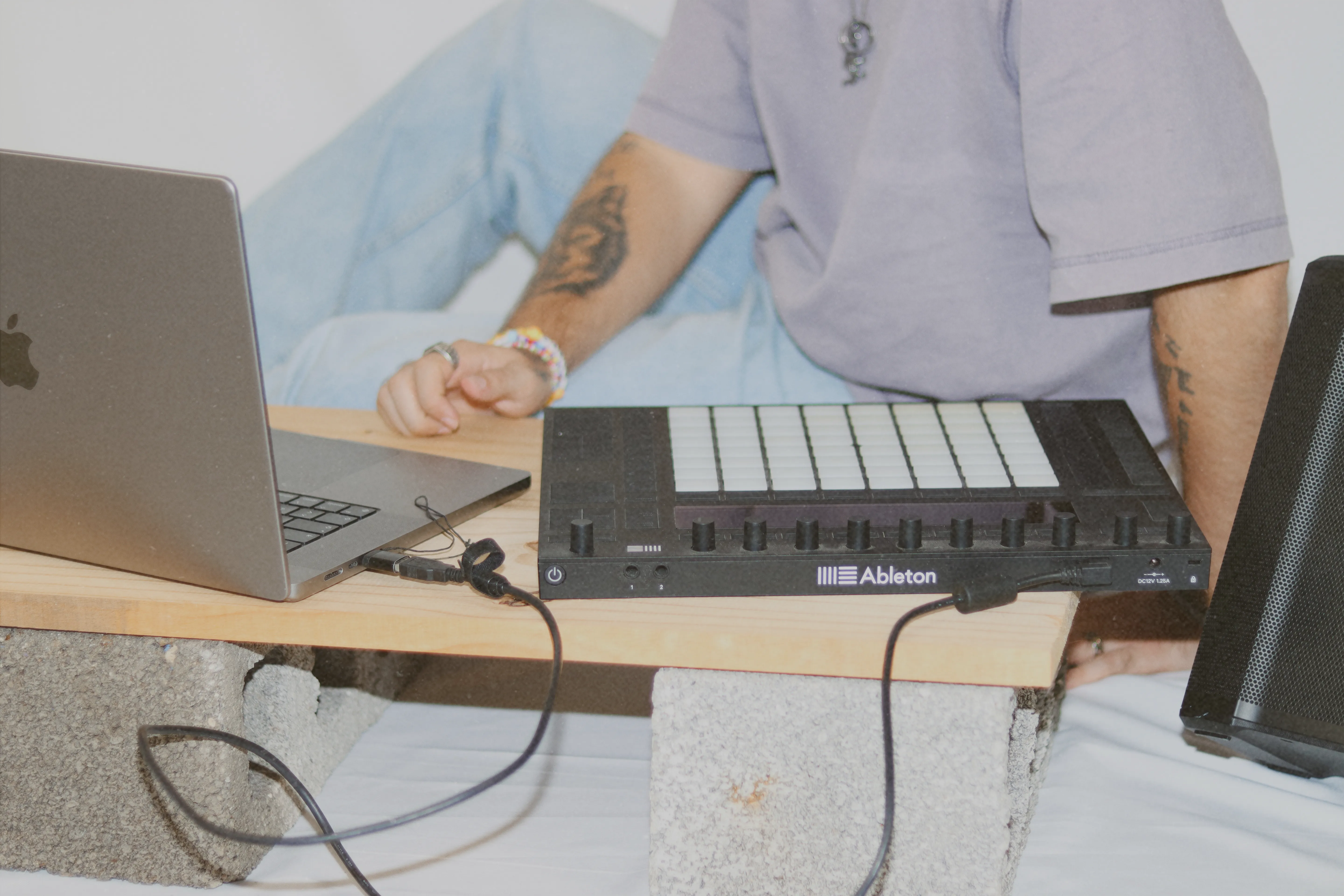 Artista trabajando con laptop y controlador Ableton Push