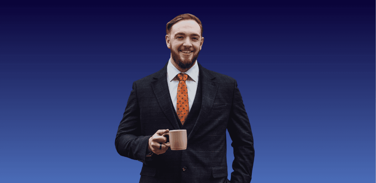 A man in a suit. He's smiling, has short hair and a beard