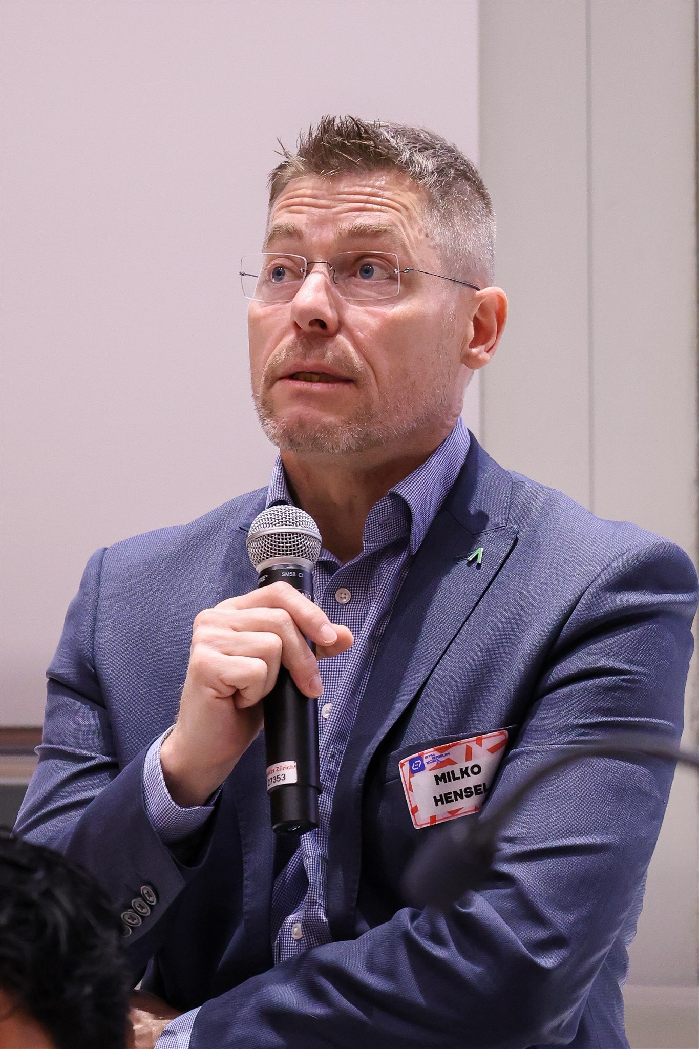 Speaker presenting with microphone at EthereumZüri conference in Zurich