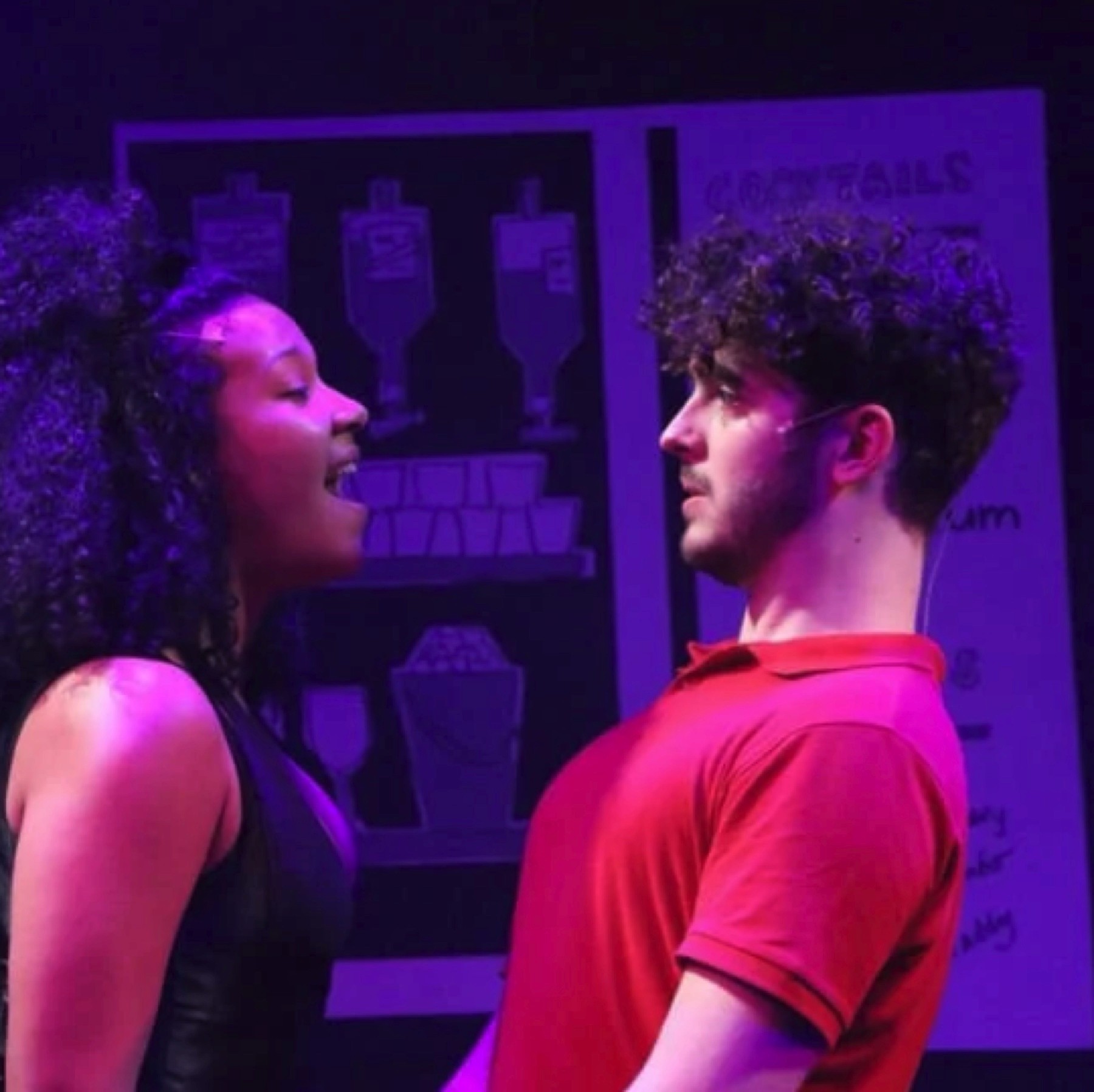 Two Bromance performers facing each other under purple stage light