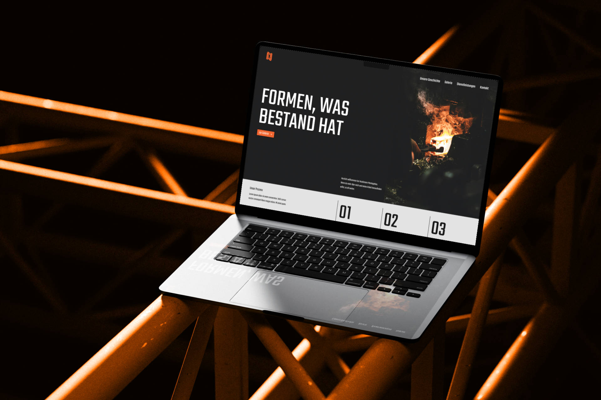 MacBook mit der Website von Haußmann Montagebau, gestaltet in einem grafisch-geometrischen Design in Schwarz und Orange. Der Laptop steht auf einem auffälligen orangenen Stahlträger.