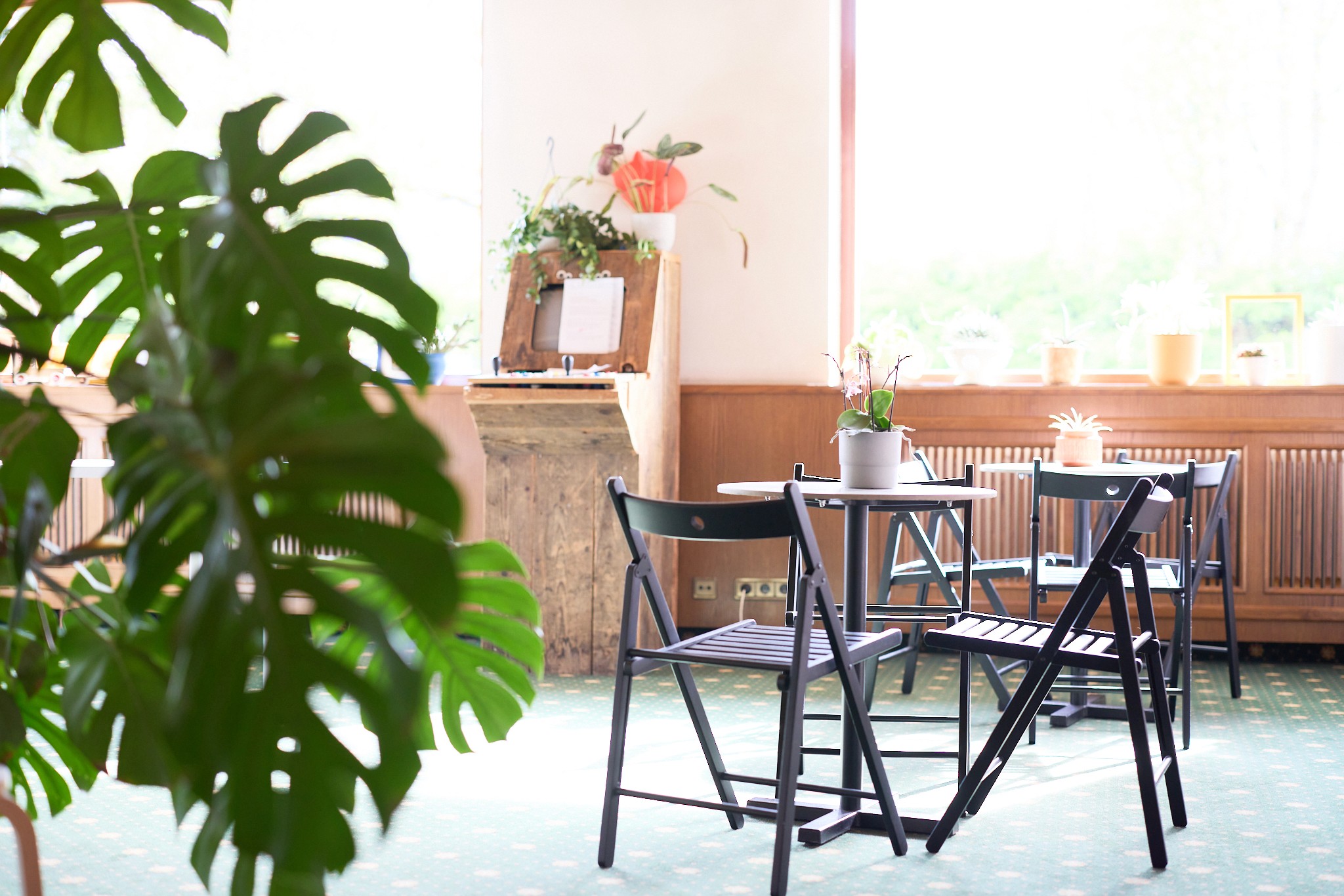 schwarze stühle an grauem betontischchen und oldschoolcomuter im background