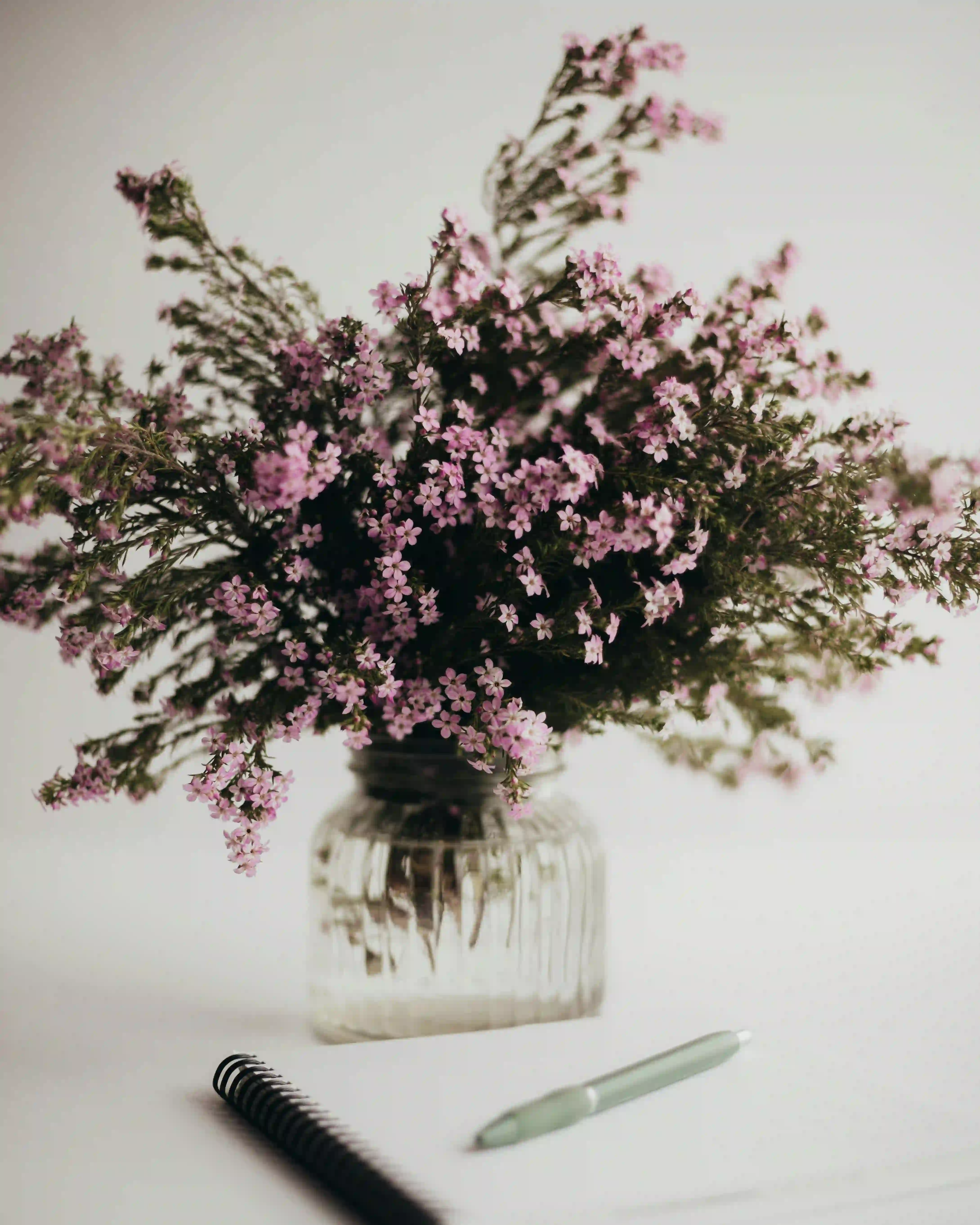 Pot de fleurs élégant accompagné d'un carnet et d'un stylo, invitant à la créativité et à l'introspection